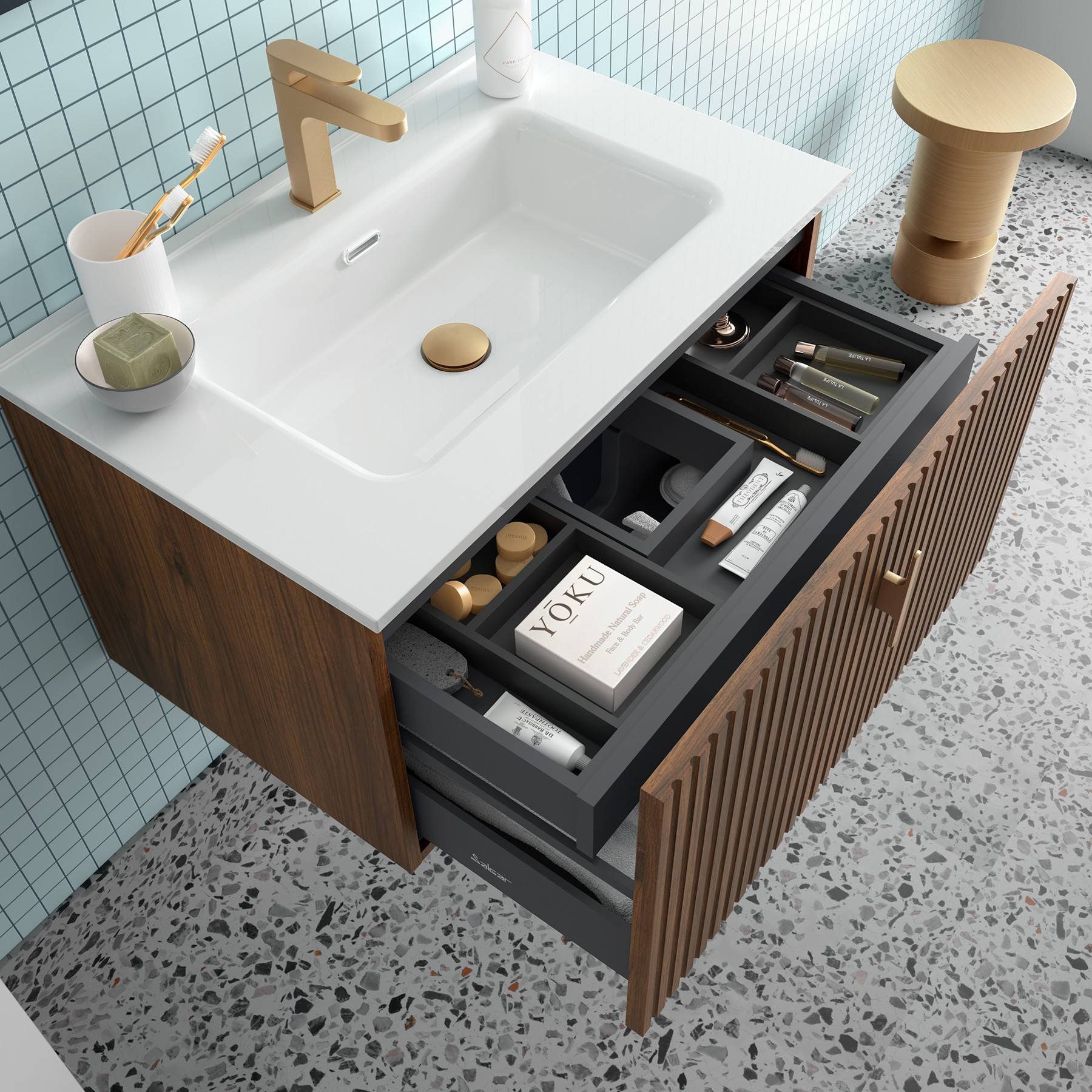 Ein Badezimmerwaschtisch mit einem weißen Waschbecken, Holzschrank, offenen Schubladen mit sortierten Toilettenartikeln und einem Terrazoboden.