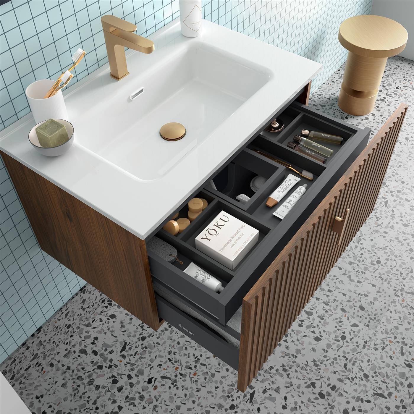 Modernes Badezimmer-Waschtisch mit weißem Waschbecken und goldenem Wasserhahn, offene Schubladen zeigen Toilettenartikel und Körperpflegeartikel, Holzschrank mit Lamellentüren.