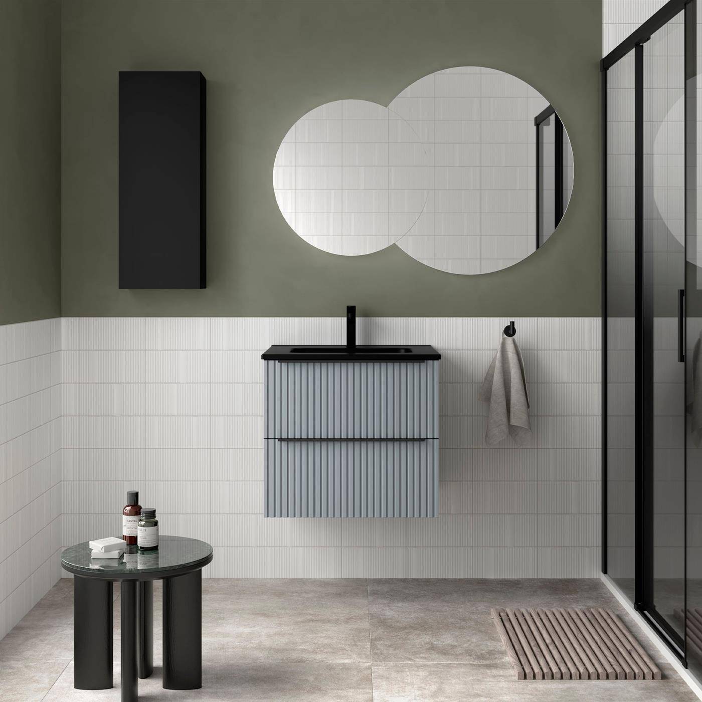 Modernes Badezimmer mit olivfarbenen Wänden, weißen Fliesen, schwebendem Waschtisch und rundem Spiegel, schwarzen Armaturen, Duschkabine und kleinem Beistelltisch.