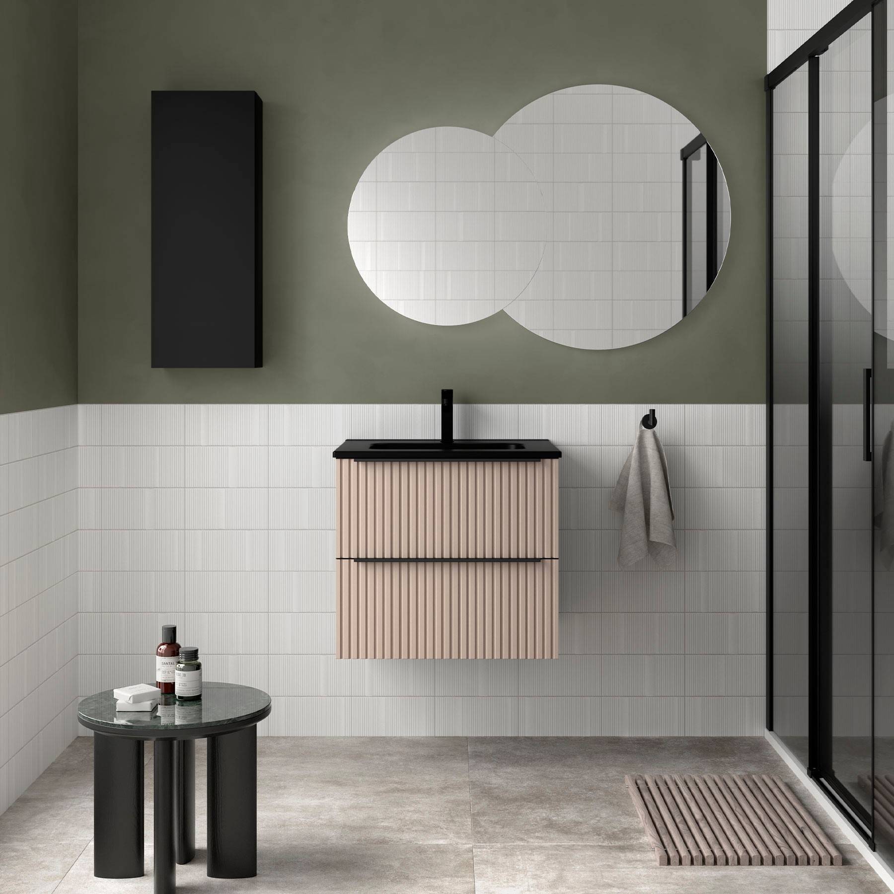 Ein modernes Badezimmer verfügt über einen runden Spiegel, grüne Wände, einen schwarzen Schrank, eine Handtuchstange, einen kleinen Tisch mit Toilettenartikeln und eine Duschkabine aus Glas.