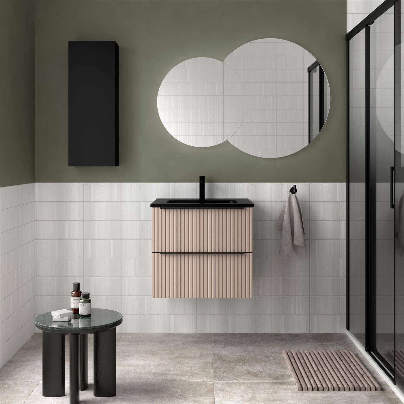Modernes Badezimmer mit olivgrünen Wänden, zwei runden Spiegeln, an der Wand montiertem Waschtisch, Glasdusche und einem kleinen runden Beistelltisch mit Toilettenartikeln.