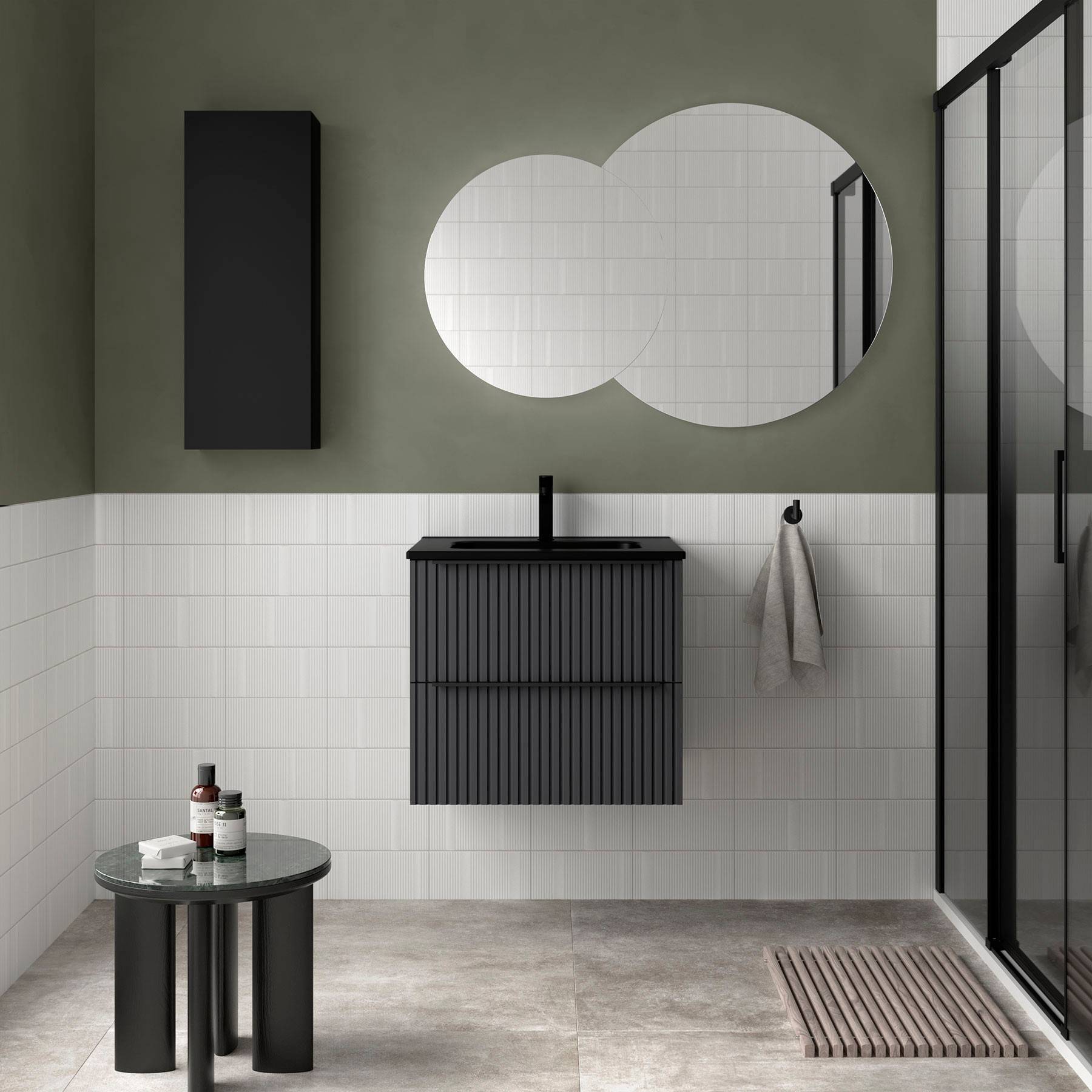 Modernes Badezimmer mit einem runden Spiegel, schwarzem Waschtisch, grüner Wand und Glasdusche. Minimalistisches Design mit klaren Linien.