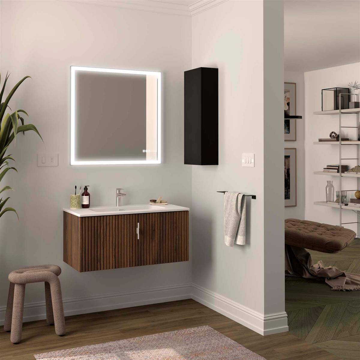 Modernes Badezimmer-Waschtisch mit beleuchtetem Spiegel, wandmontiertem Schrank und Handtuchstange neben einer offenen Türöffnung zu einem Schlafzimmer oder Ankleidezimmer.
