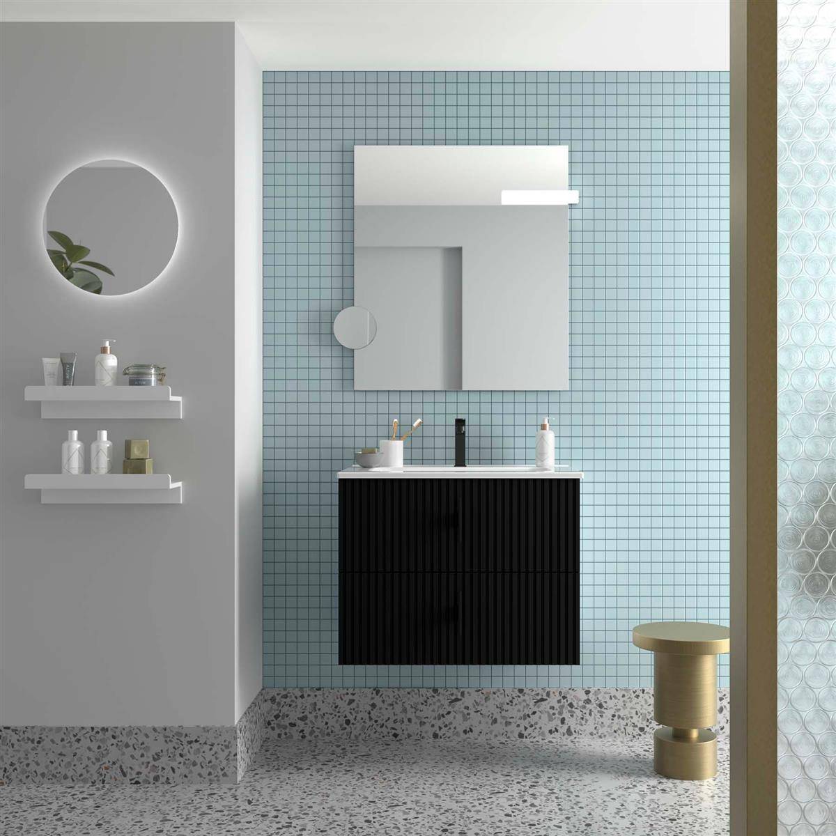 Modernes Badezimmerinterieur mit blauer gekachelter Wand, Spiegel über schwarzem Waschtisch, und Regalen mit Toilettenartikeln neben einem runden Spiegel.