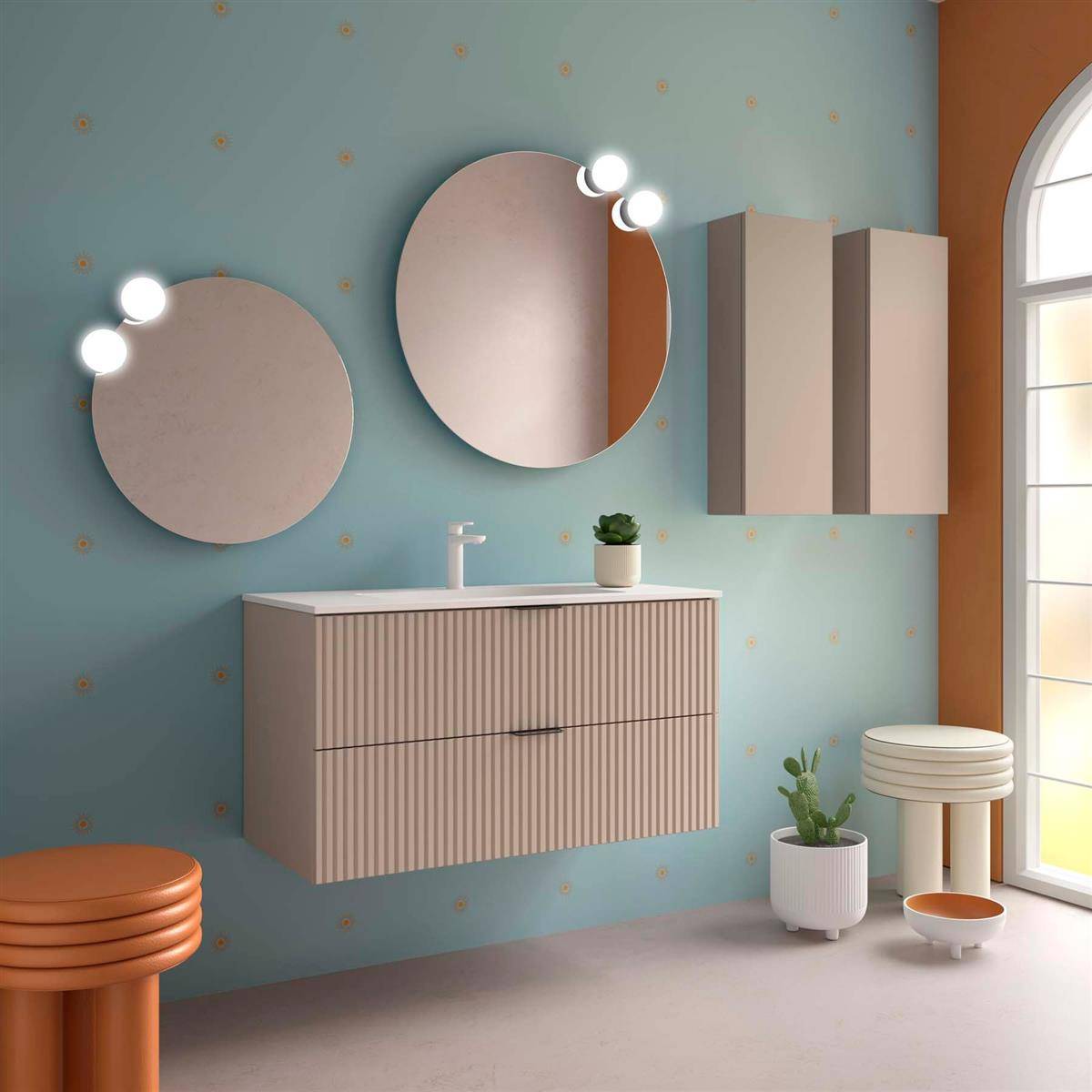 Stilvoller Badezimmerschrank mit zwei runden Spiegeln und Beleuchtung, Wandschrank, Waschbecken, Topfpflanzen und Fenster neben einer orangefarbenen Akzentwand.