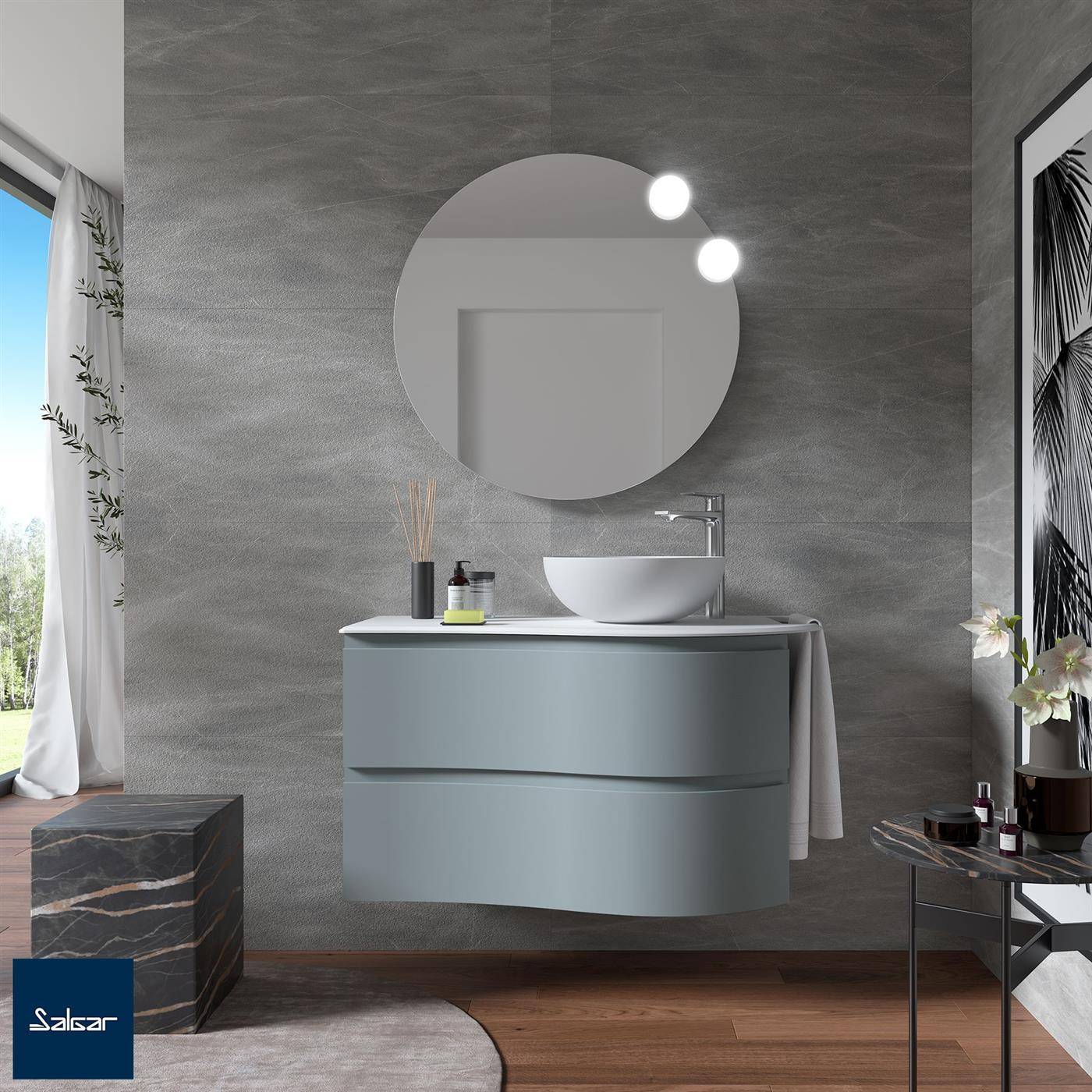 Modernes Badezimmer mit an der Wand montiertem, geschwungenem Waschtisch, rundem Spiegel, Aufsatzwaschbecken und grauen Steinwänden; große Fenster sorgen für natürliches Licht.