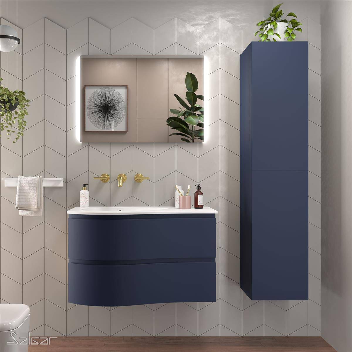 Modernes Badezimmer mit marineblauen Waschtischunterschrank und hochem Schrank, beleuchtetem Spiegel, Messingarmaturen, weißen Fliesenswänden und Pflanzen.