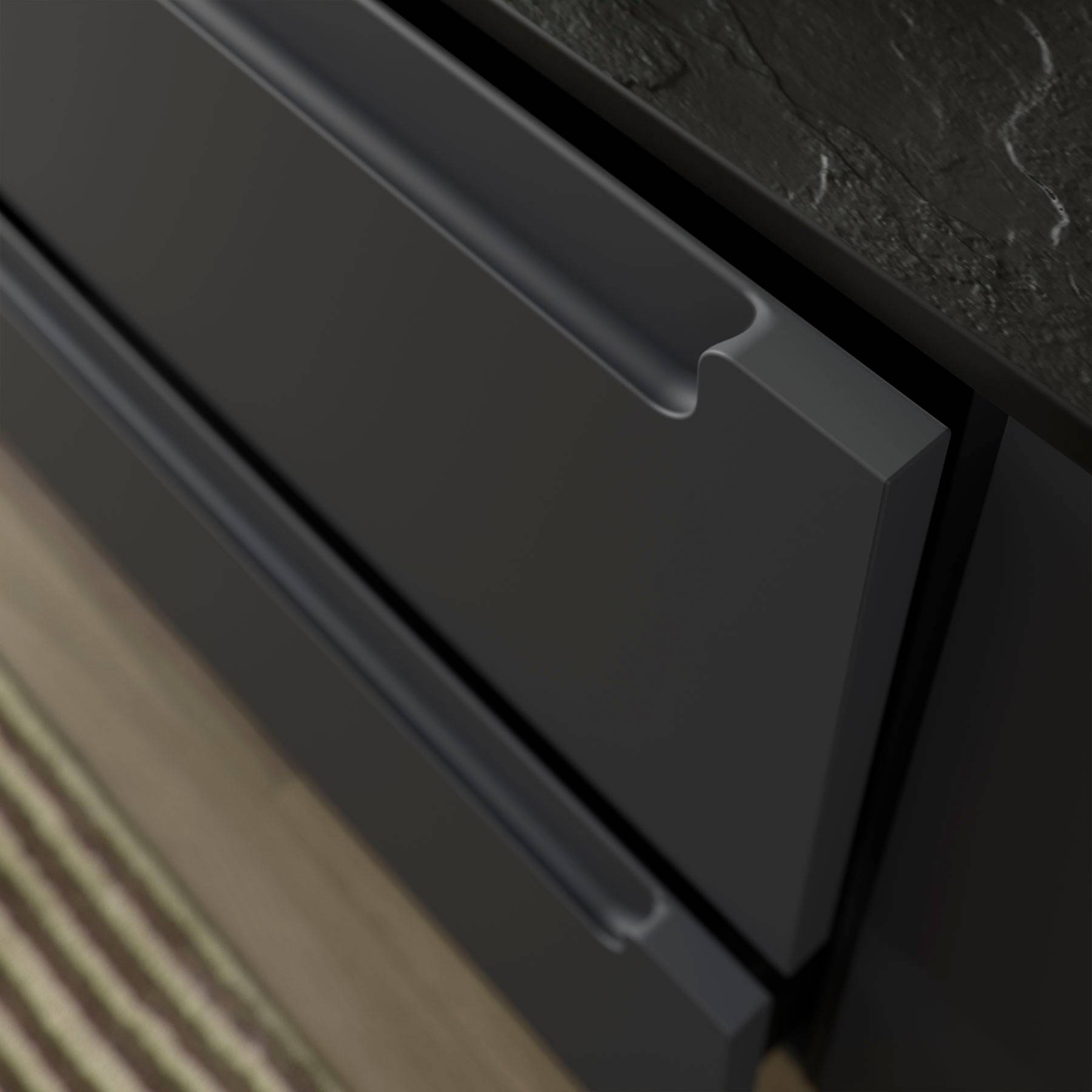 Nahaufnahme eines modernen Küchenschranks mit einem dunkelgrauen Griff, vor einem kontrastierenden hellholzfarbenen Boden und einer dunklen Arbeitsplatte.