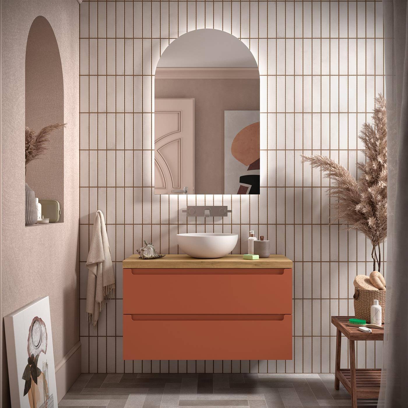 Modernes Badezimmer mit schwebendem orangefarbenem Waschtisch, rundem Waschbecken, gewölbtem Spiegel, beigefliesen Wand und dekorativen getrockneten Pflanzen.