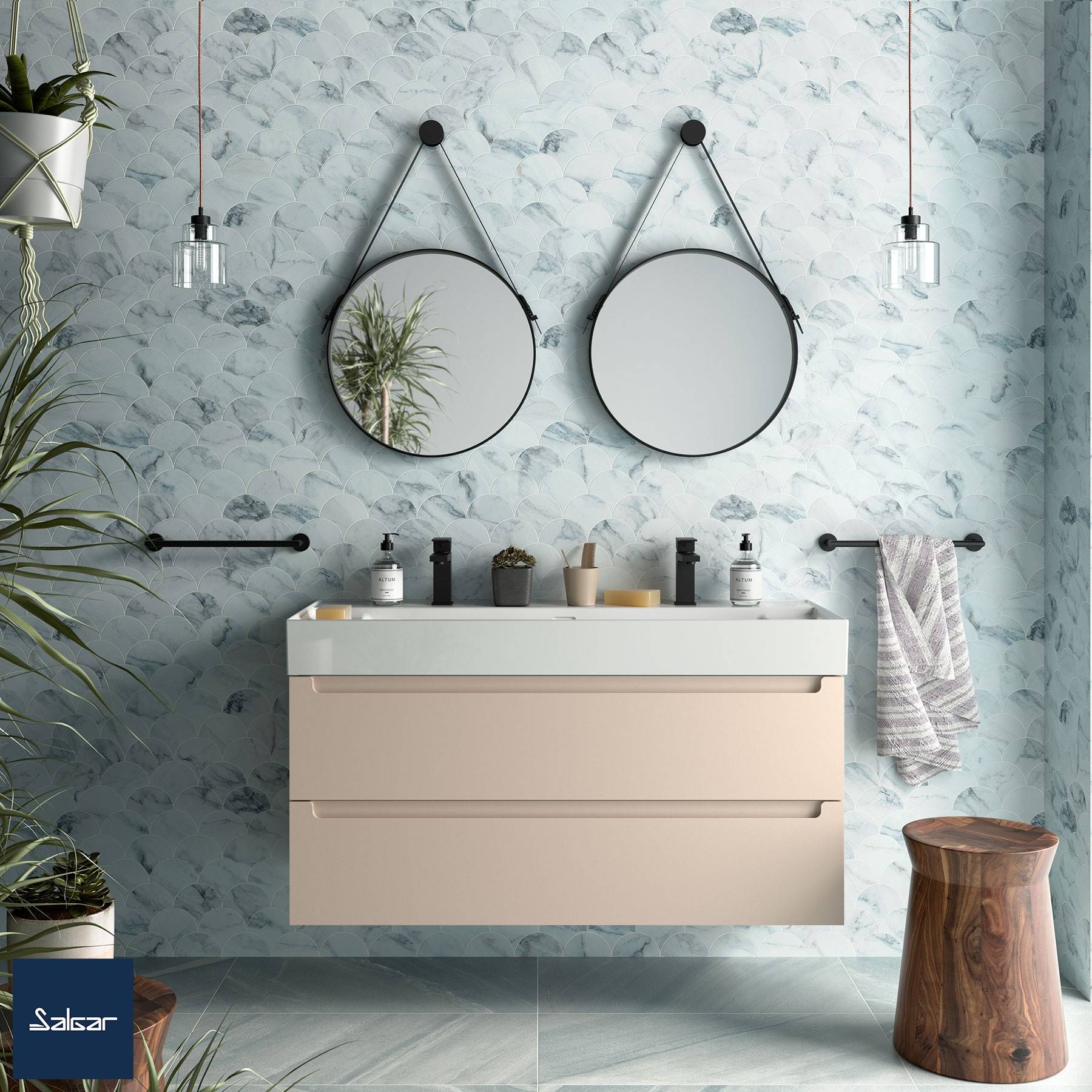 Ein modernes Badezimmer mit zwei runden Spiegeln, einer hängenden Leuchte und einem beigen Waschtisch vor einer gemusterten Wand, ausgestattet mit minimalistischer Dekoration.