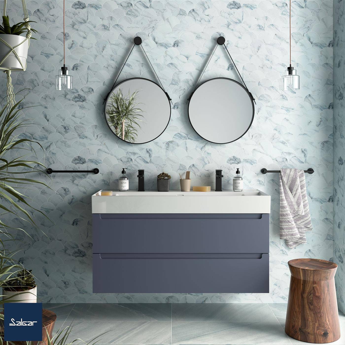 Modernes Badezimmer mit schwebendem dunklem Waschtisch, doppelten runden Spiegeln, Wandleuchten und hellblauer gemusterter Tapete.