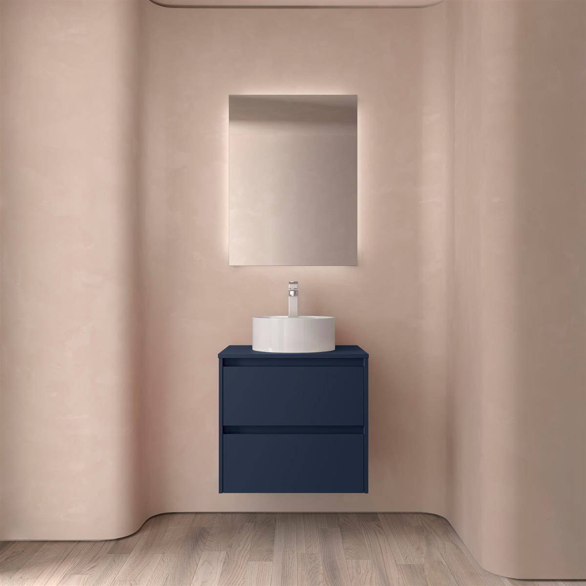 Minimalistischer Badezimmerwaschplatz mit rechteckigem Spiegel, weißem Waschbecken und dunklem blauem hängendem Schrank an einer sanften beigefarbenen Wand.