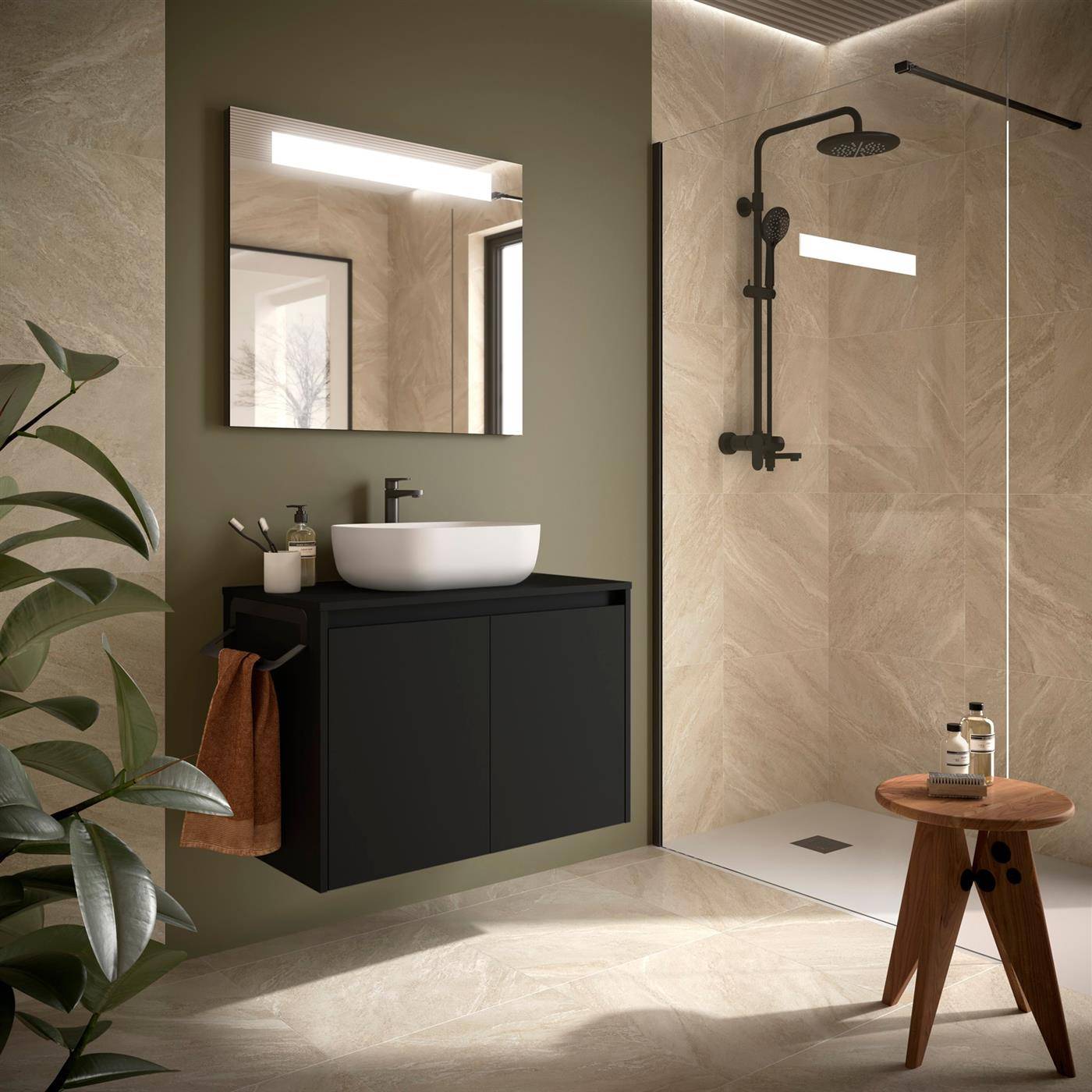 Modernes Badezimmer mit wandmontiertem schwarzem Waschtisch und Aufsatzwaschbecken neben einer Glasdusche, beleuchtet durch einen Spiegelt und eine Deckenleuchtenleiste; eine Pflanze und ein Holzhocker vervollständigen die Einrichtung.