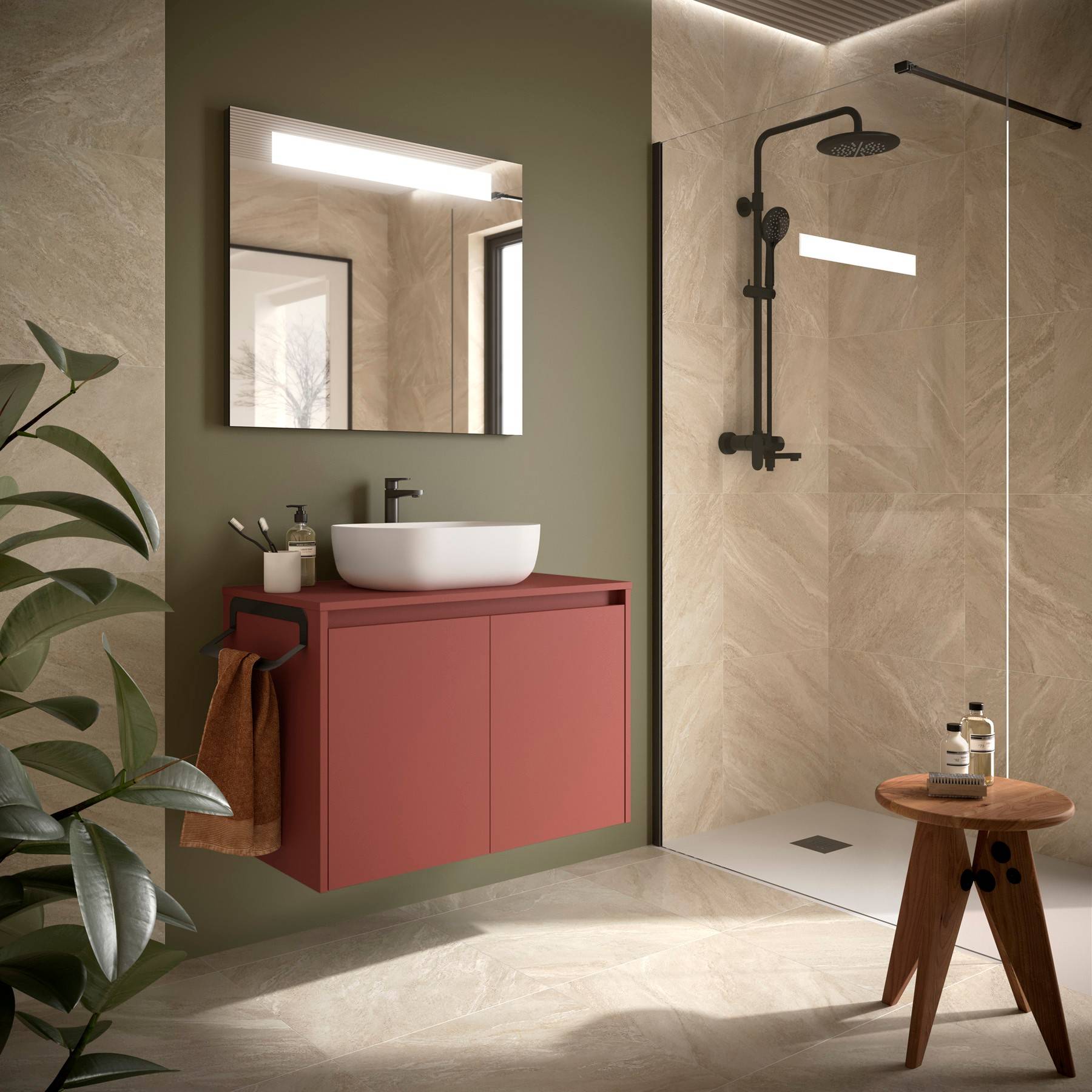 Modernes Badezimmer mit grün und beige Wänden, einem roten Waschtisch mit Waschbecken, Spiegel und schwarzer Duscharmatur. Ein Holzhocker und Pflanzen ergänzen die Dekoration.