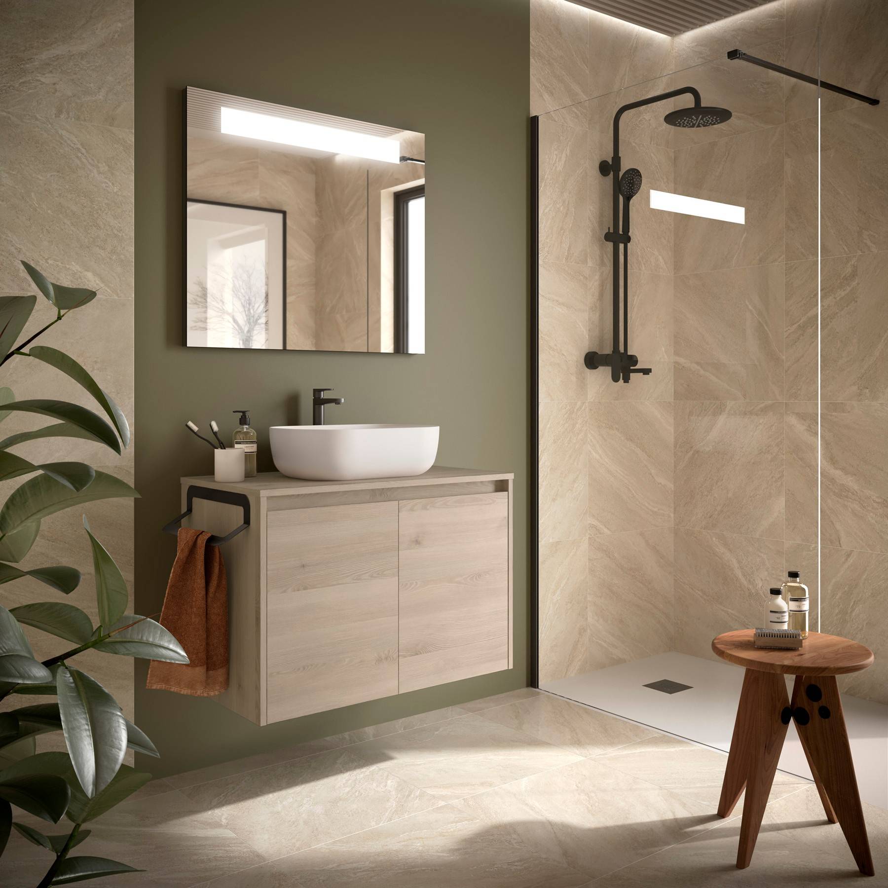 Modernes Badezimmer mit einem Waschtisch aus Holz, rundem Spiegel und begehbarer Dusche. Beige-Fliesen und eine grüne Wand verleihen Wärme. Eine Pflanze steht in der Nähe.