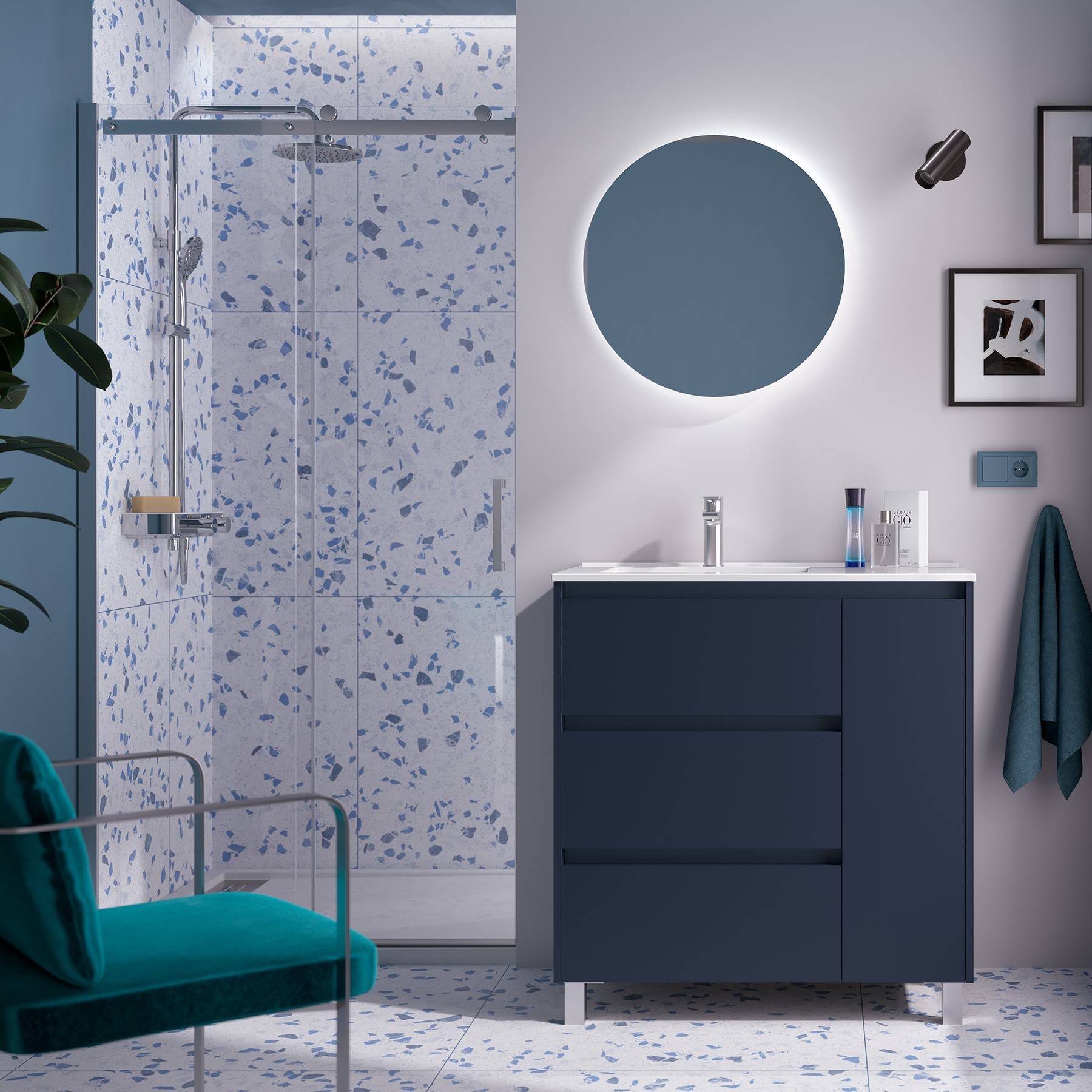 Modernes Badezimmer mit einer blauen Waschtischplatte, rundem Spiegel und Glasdusche. Weiße und blaue Terrazofliesen bedecken Wände und Boden.