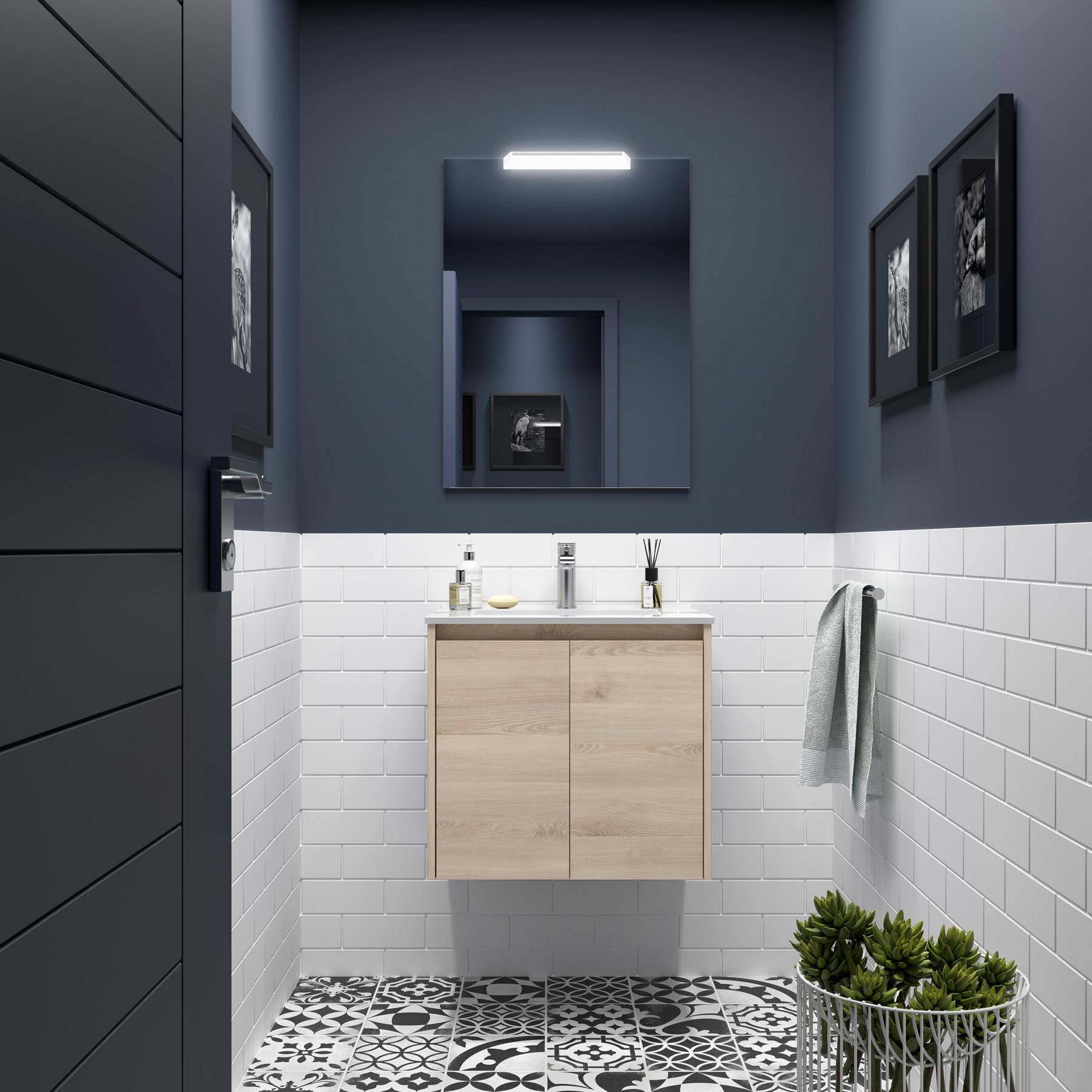 Ein modernes Badezimmer mit einer Holz-Waschtischplatte, weißen Metrofliesen, geometrischen Bodenfliesen, dunkelblauen Wänden und gerahmten Bildern.