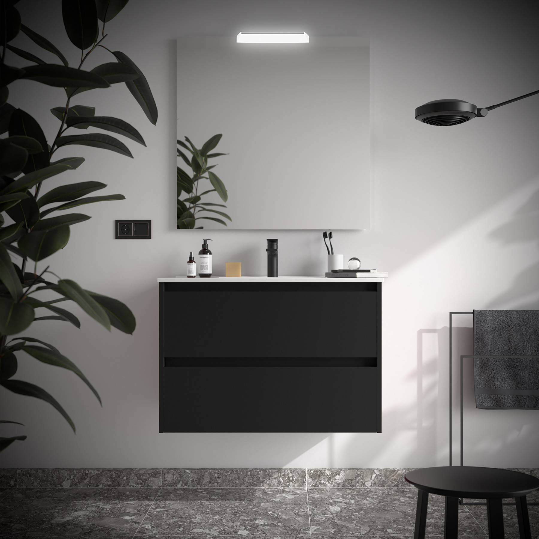 Modernes Badezimmer mit einem wandmontiertem schwarzen Waschtisch, quadratischem Spiegel und Topfpflanzen. Ein schwarzer Hocker und eine Leuchte unterstreichen das minimalistische Design.