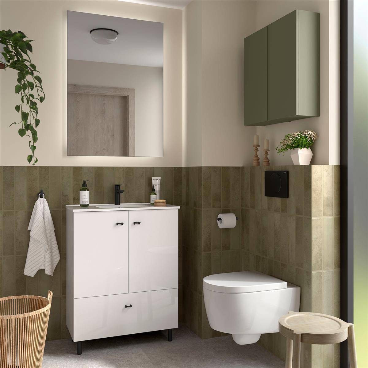 Modernes Badezimmer mit an der Wand montierter Toilette, weißem Waschtisch und Spiegel, grünen Fliesenwänden, Schrank, Handtüchern und geflochtenem Stuhl neben einem kleinen Hocker.