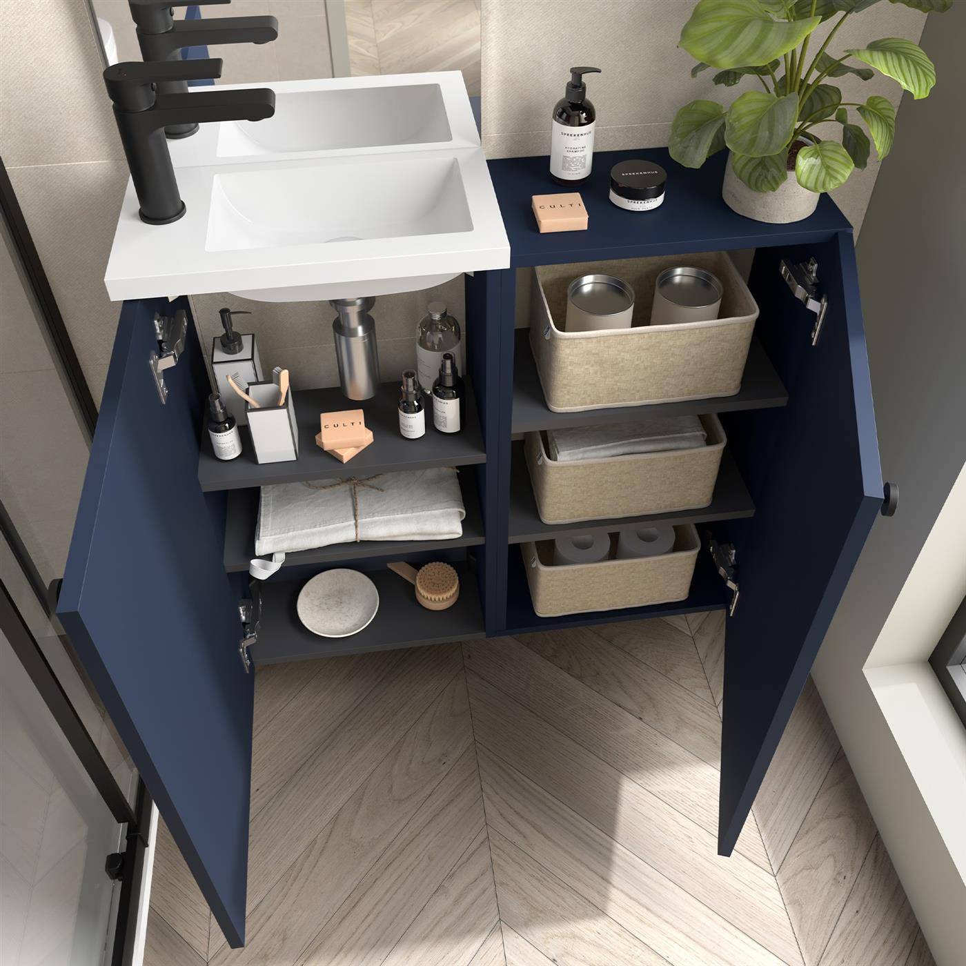Offener Marinebadezimmer-Waschtischschrank mit Waschbecken, organisierten Regalen, Körben, Toilettenartikeln, Handtüchern, Seifenspender und einer Pflanze oben.
