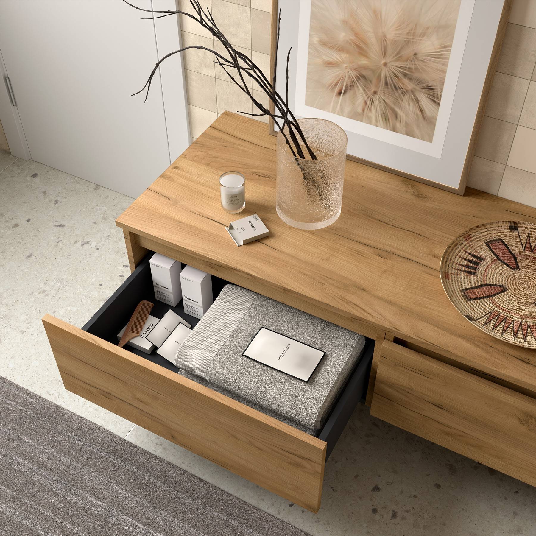 Ein Holzschrank mit einer offenen Schublade, in der Bücher und Schreibwaren ordentlich sortiert sind. Eine Vase mit Zweigen und Dekoration steht oben drauf.