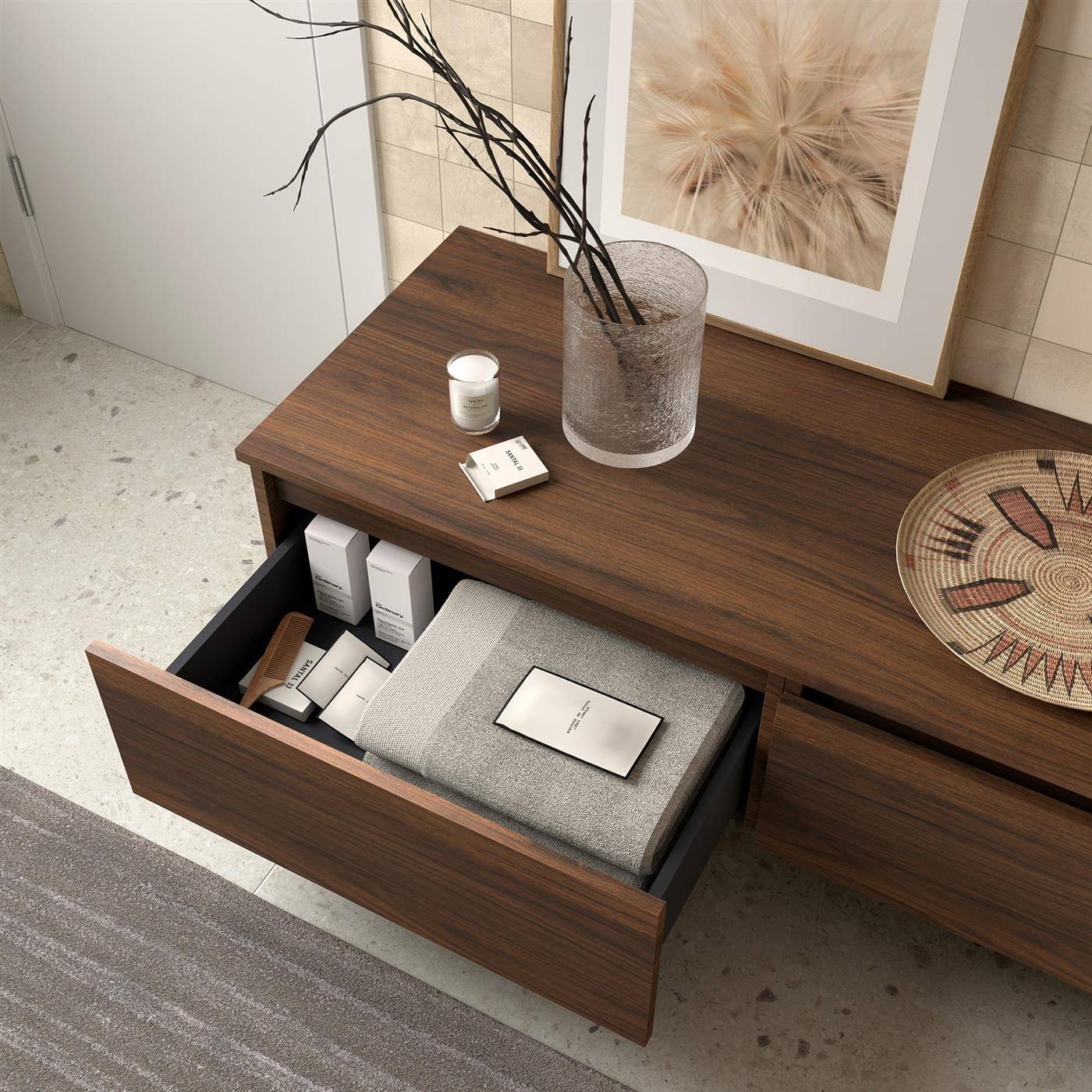 Modernes Holz-Sideboard mit einer offenen Schublade, die gefaltete Handtücher, Boxen und Toilettenartikel zeigt; Vase, Kerze, gerahmte Kunst und dekoratives Tablett auf der Oberseite.