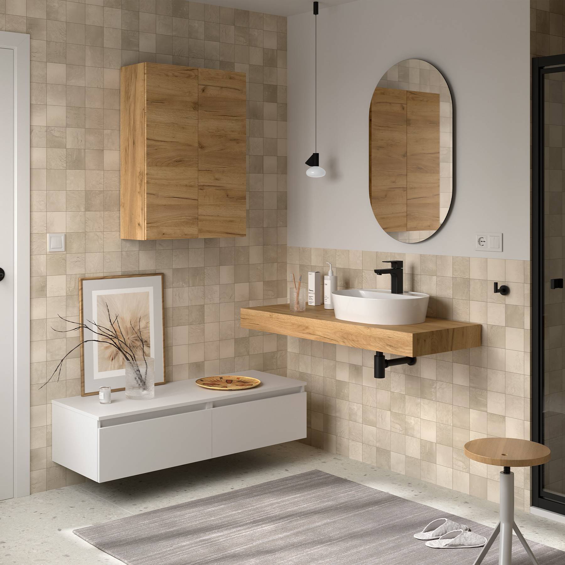 Modernes Badezimmer mit beigen gefliesten Wänden, Holzschrank und Waschtisch, rundem Spiegel und minimalistischer Dekoration. Eine kleine Pflanze und ein gerahmtes Kunstwerk stehen auf einem niedrigen Regal.