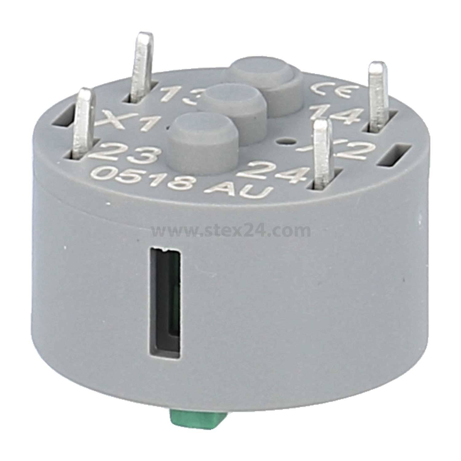 Eine graue, runde elektronische Komponente mit mehreren Metallstiften, die auf der Oberseite mit '13', '14', '23', '24', 'X1', 'X2' und '0518 AU' beschriftet ist.