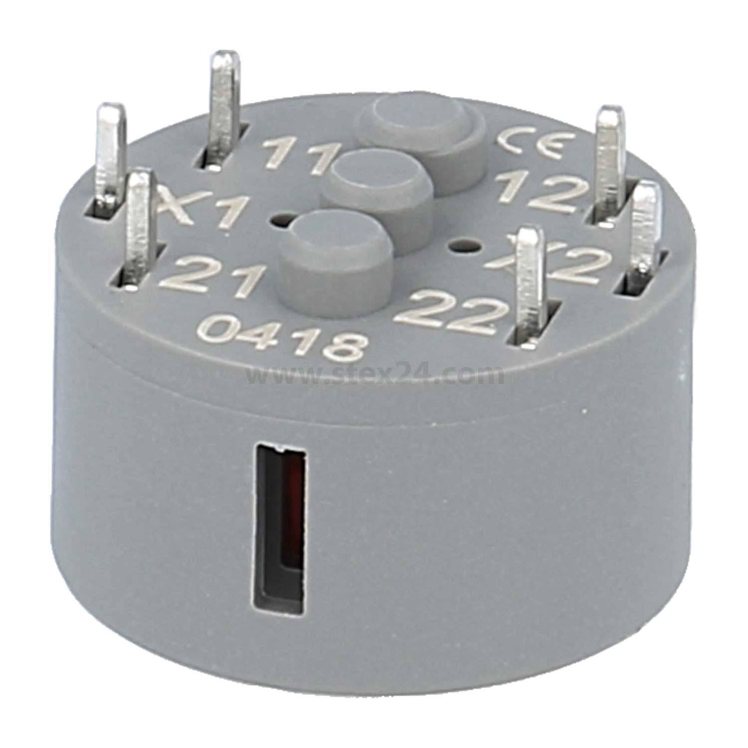 Runde graue elektrische Relais-Buchse mit mehreren Metallstiften, beschriftet mit: 11, X1, 12, X2, 21, 22. CE-gekennzeichnet mit der Nummer 0418.