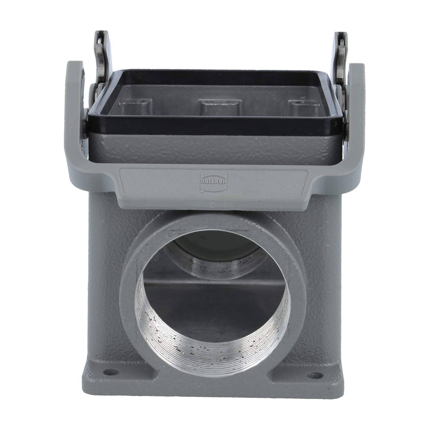 Ein grauer rechteckiger industrieller Anschlussgehäuse mit einem klappbaren Metalldeckel und einer großen kreisförmigen Öffnung am Boden für Kabeleintritt.