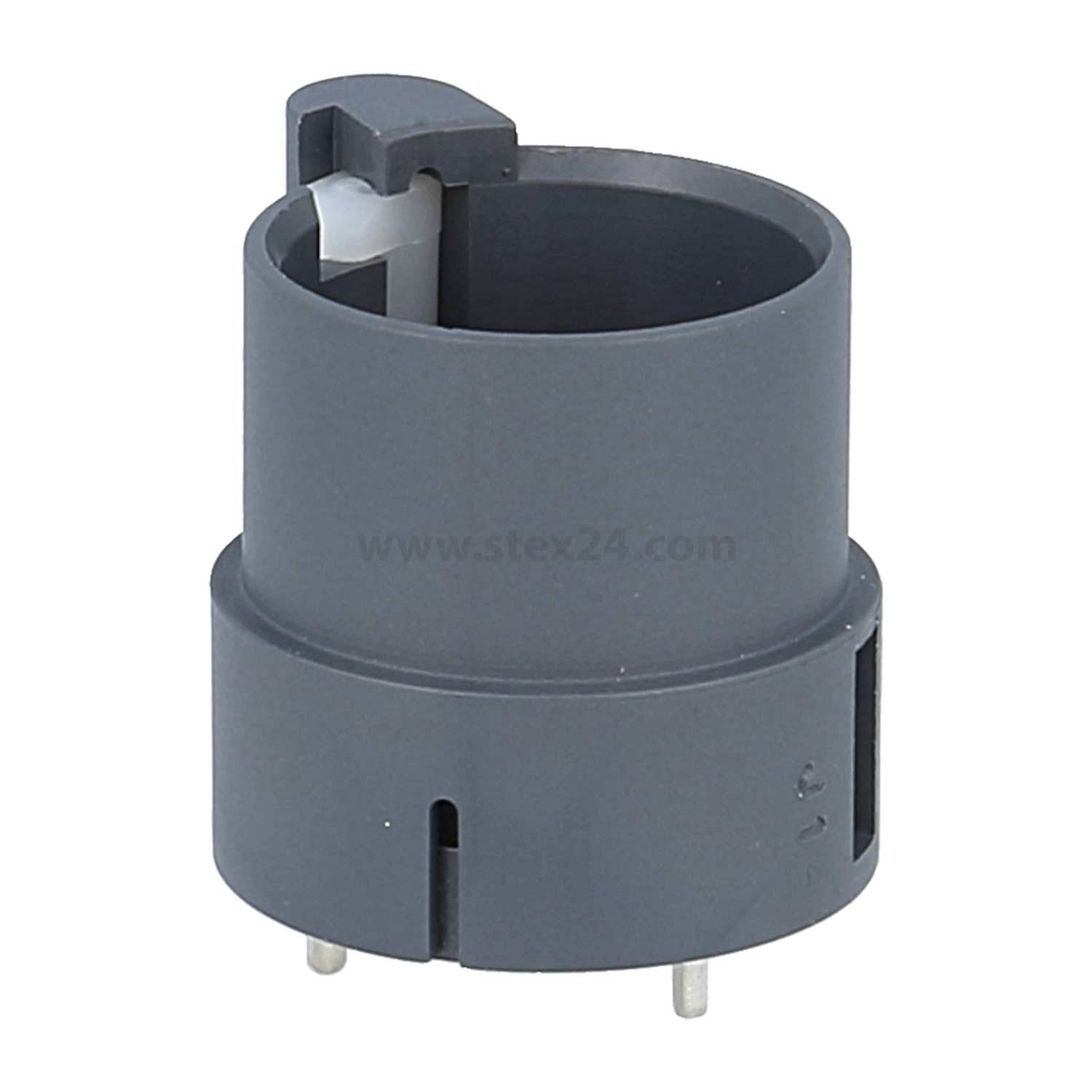 Eine zylindrische graue elektrische Komponente mit Pins an der Basis, höchstwahrscheinlich ein Sockel oder Anschluss, mit einer Clip- oder Verriegelungsmechanik an der Oberseite.