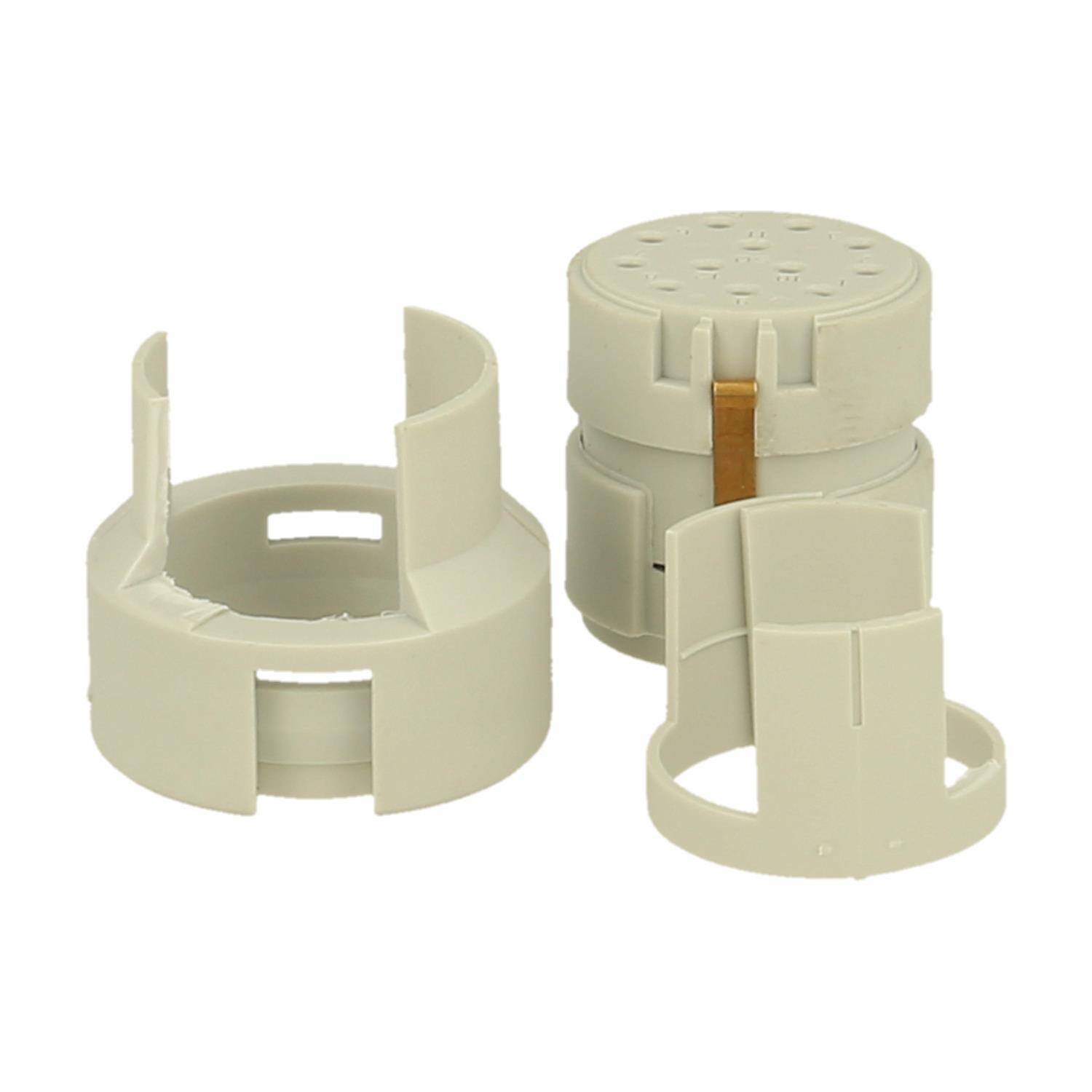 Zwei beige Kunststoffkomponenten mit zylindrischen Formen und offenen Seiten, höchstwahrscheinlich Teile einer mechanischen oder elektrischen Baugruppe.