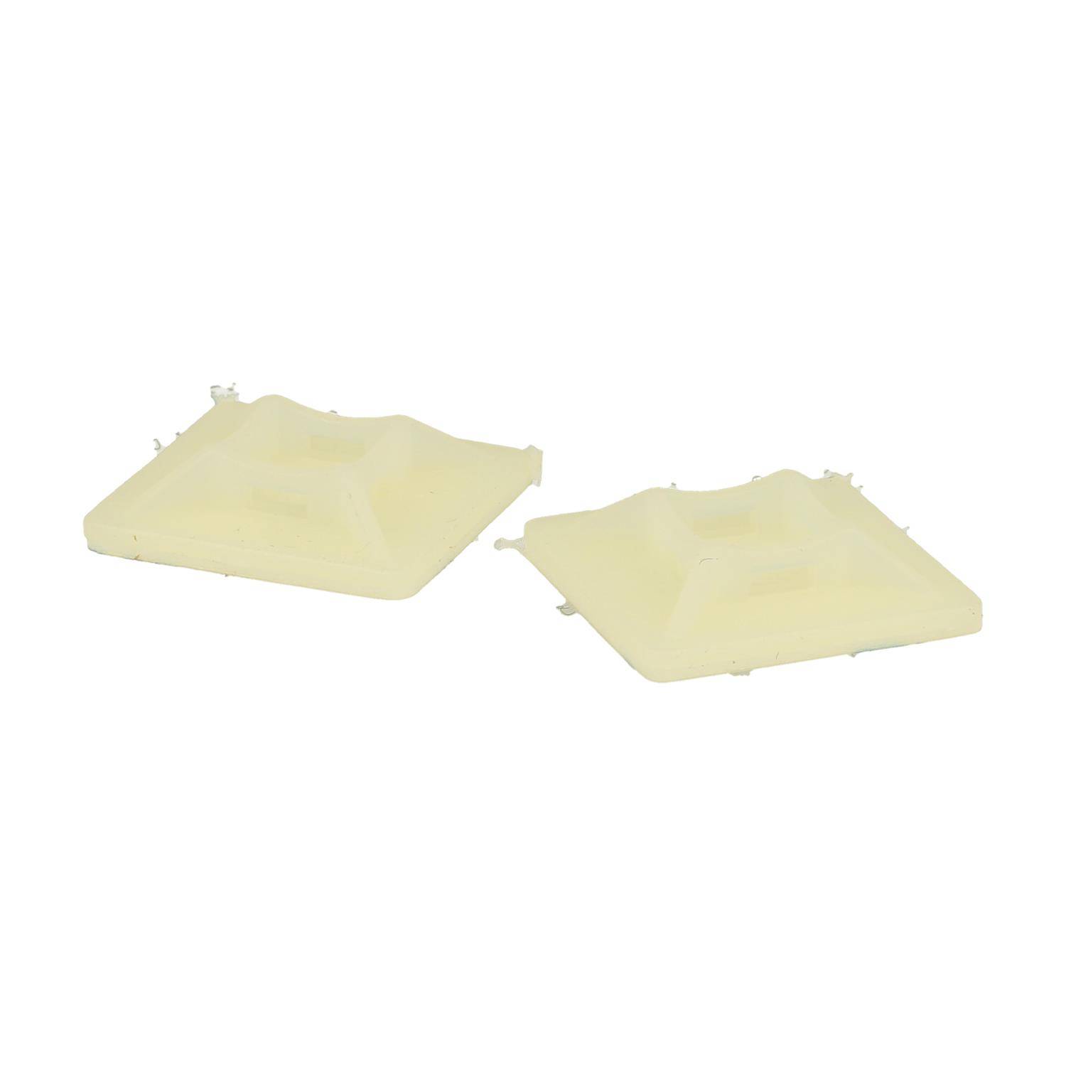 Zwei quadratische, cremefarbene Tarteformen werden vor einem schlichten Hintergrund präsentiert.