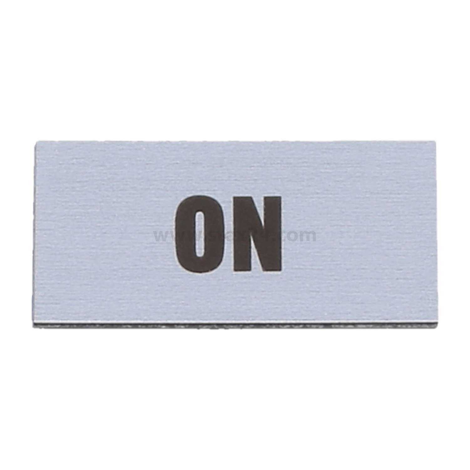 Eine Metallschalterabdeckung mit dem in Schwarz gravierten Wort 