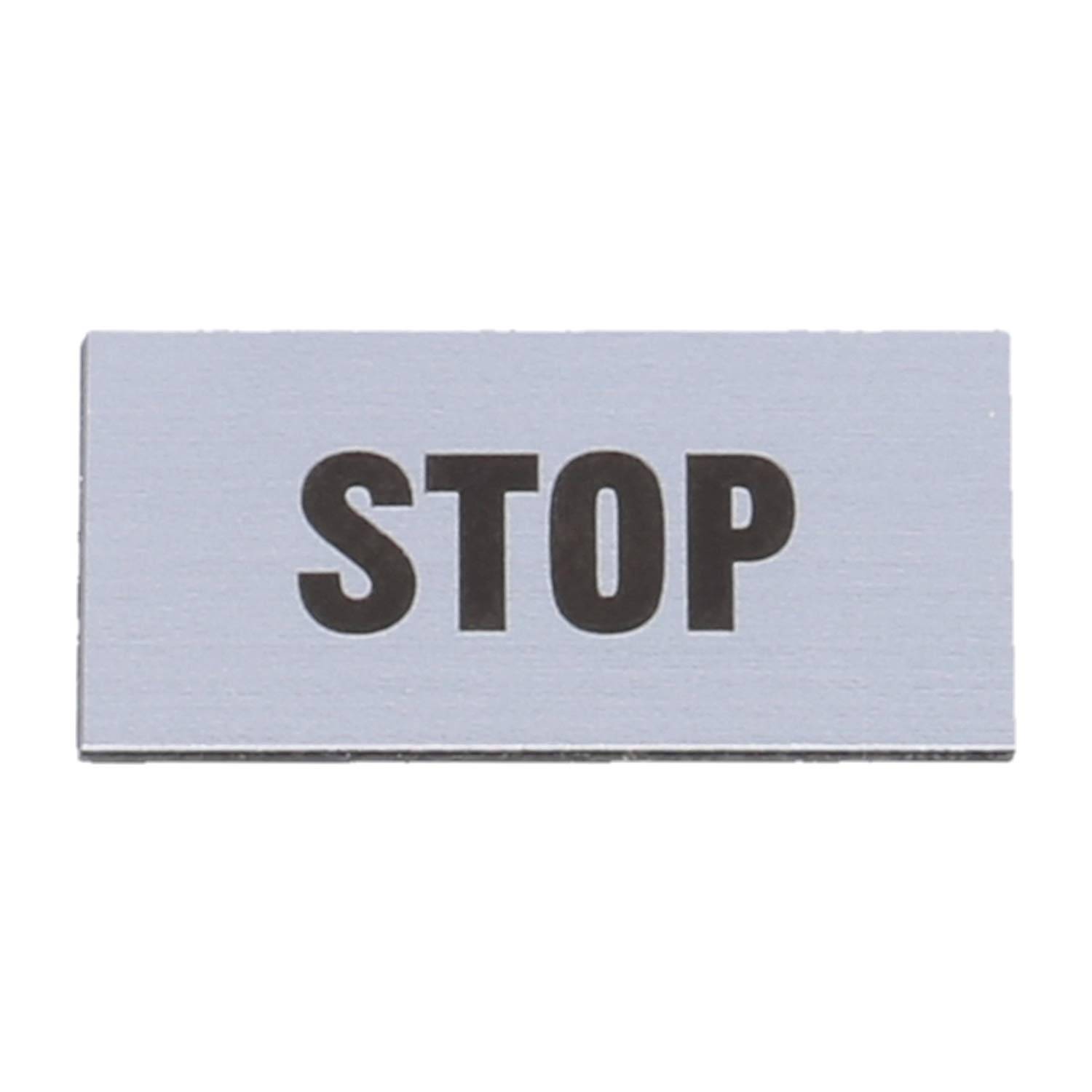 Schild mit dem Wort 'STOP' in fetter schwarzer Schrift auf einem rechteckigen silbernen Hintergrund.