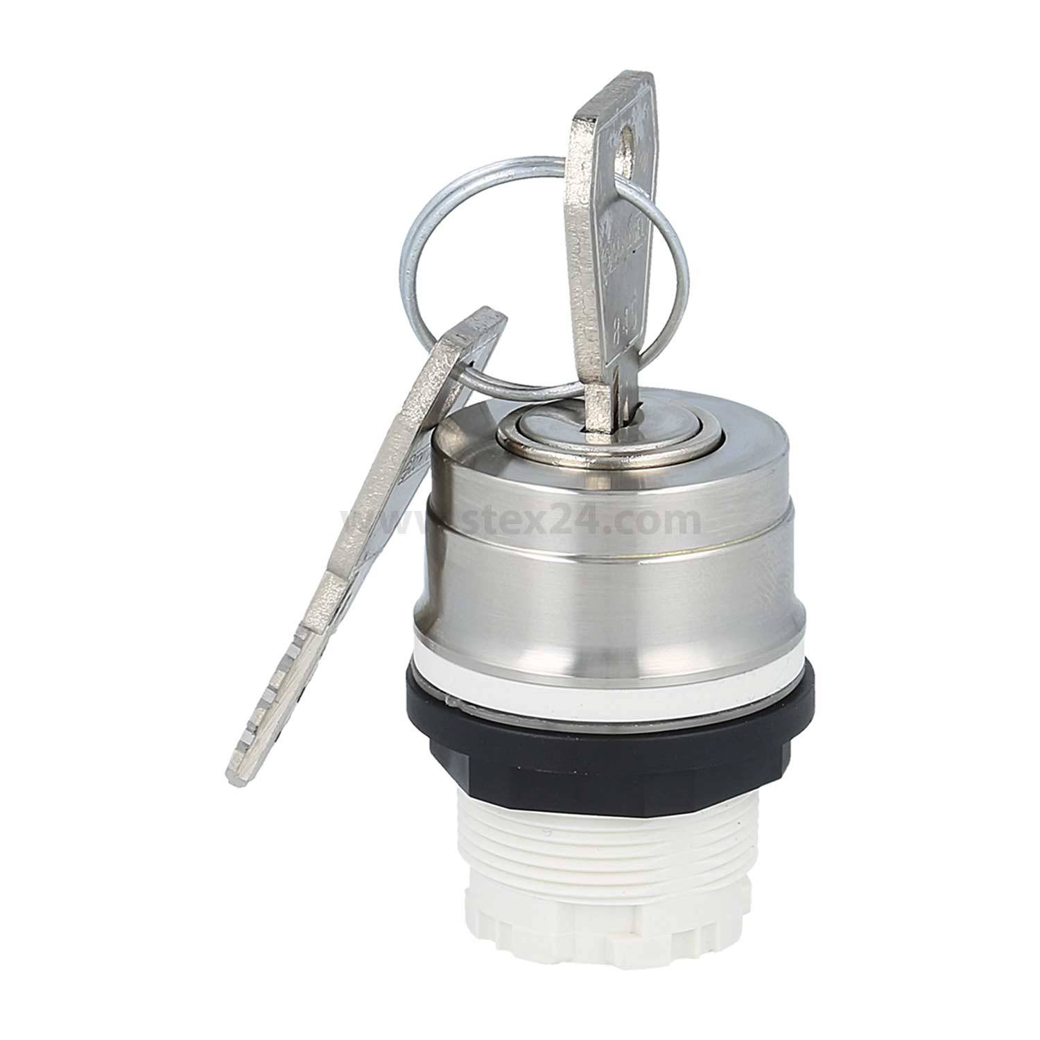 Ein metallischer Schlüssel, der in einen silbernen Schließzylinder eingeführt wird, mit einem Schlüsselanhänger. Der Zylinder ist auf einer weißen Kunststoffbasis montiert.