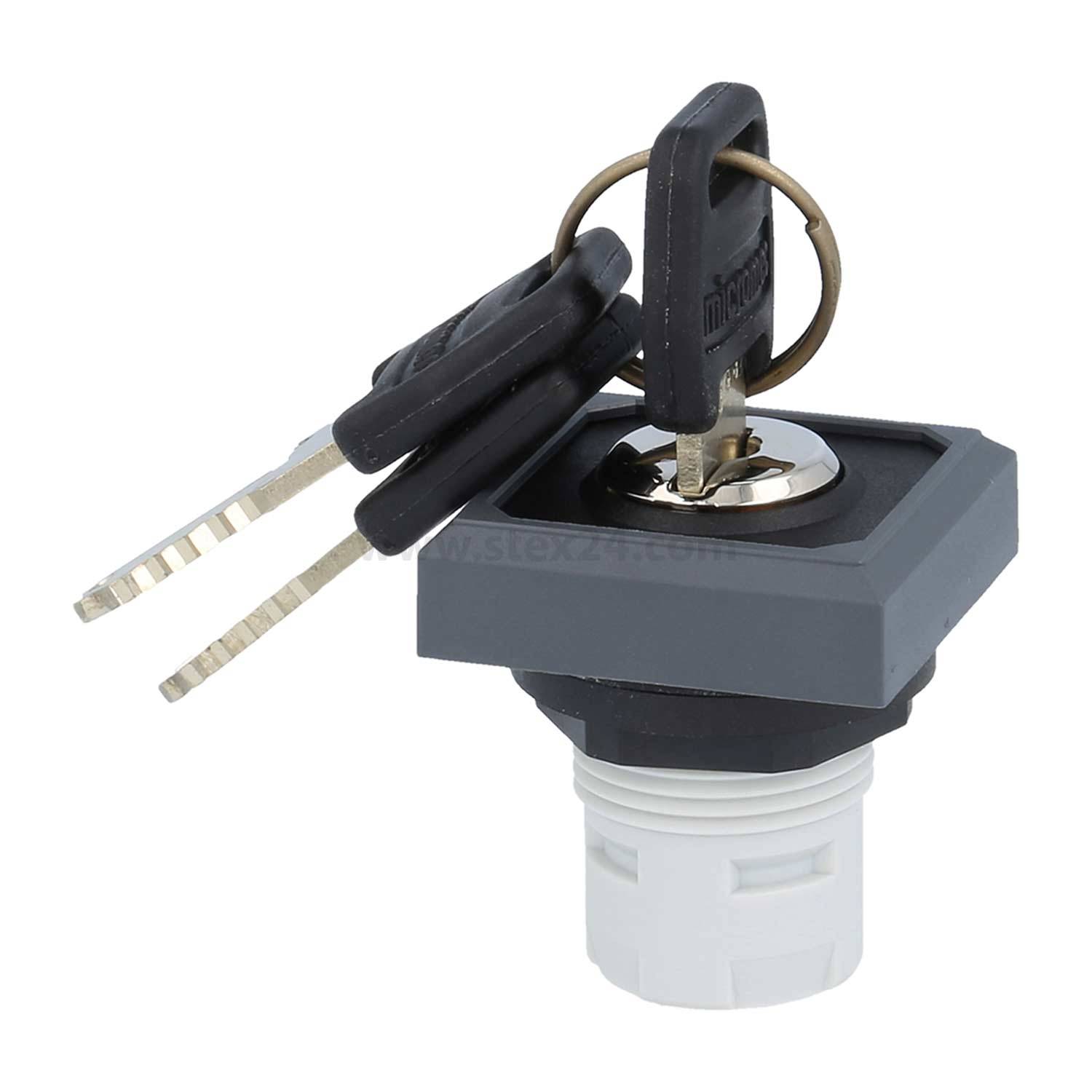 Eine Nahaufnahme eines Metallschlüssels, der in einen quadratischen, grauen Zündschalter eingesteckt ist, mit zwei weiteren Schlüsseln an einem Schlüsselring.