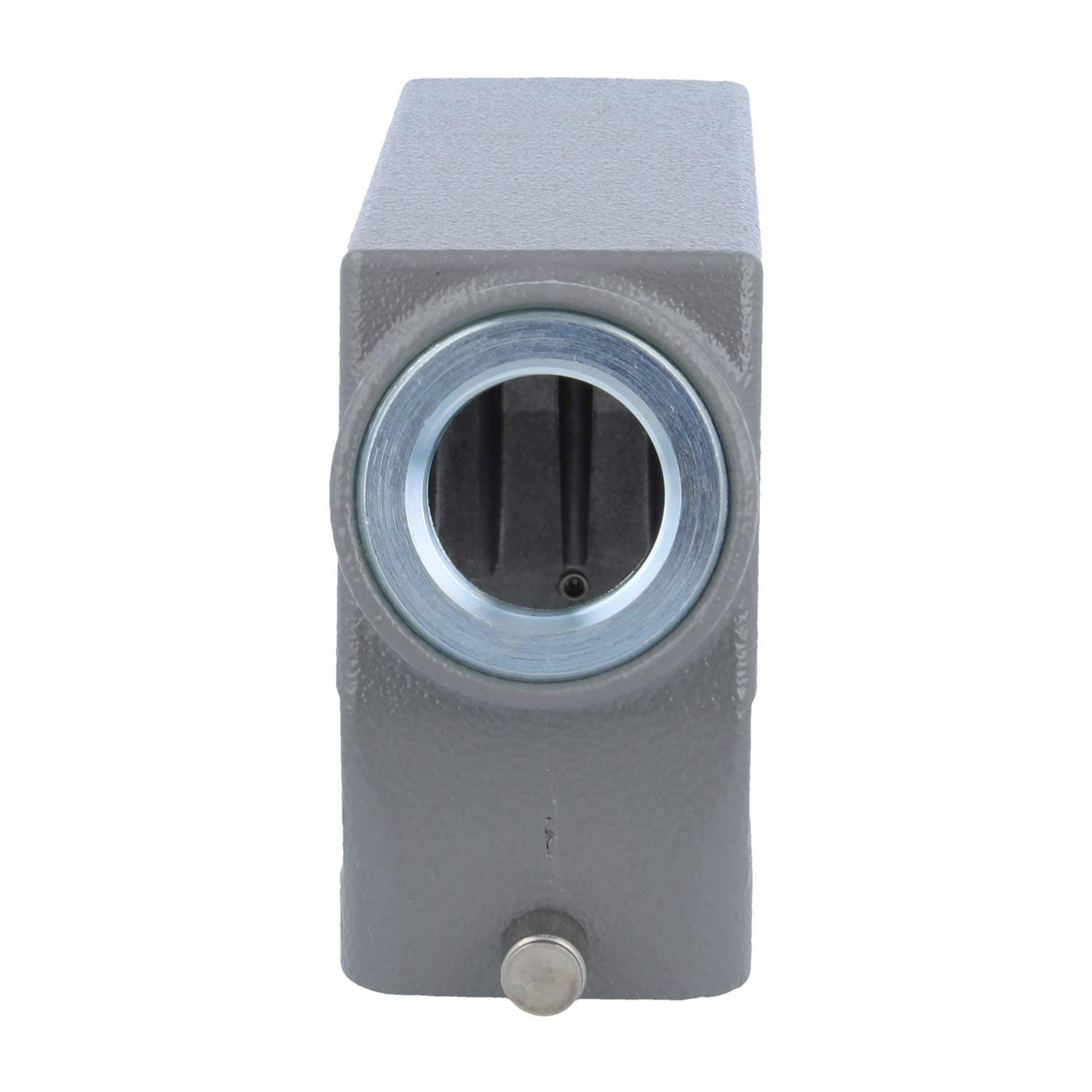 Ein grauer Industrieblock mit einer kreisförmigen Metallöffnung und einem kleinen Knopf darunter, höchstwahrscheinlich Teil einer mechanischen oder technischen Anordnung.