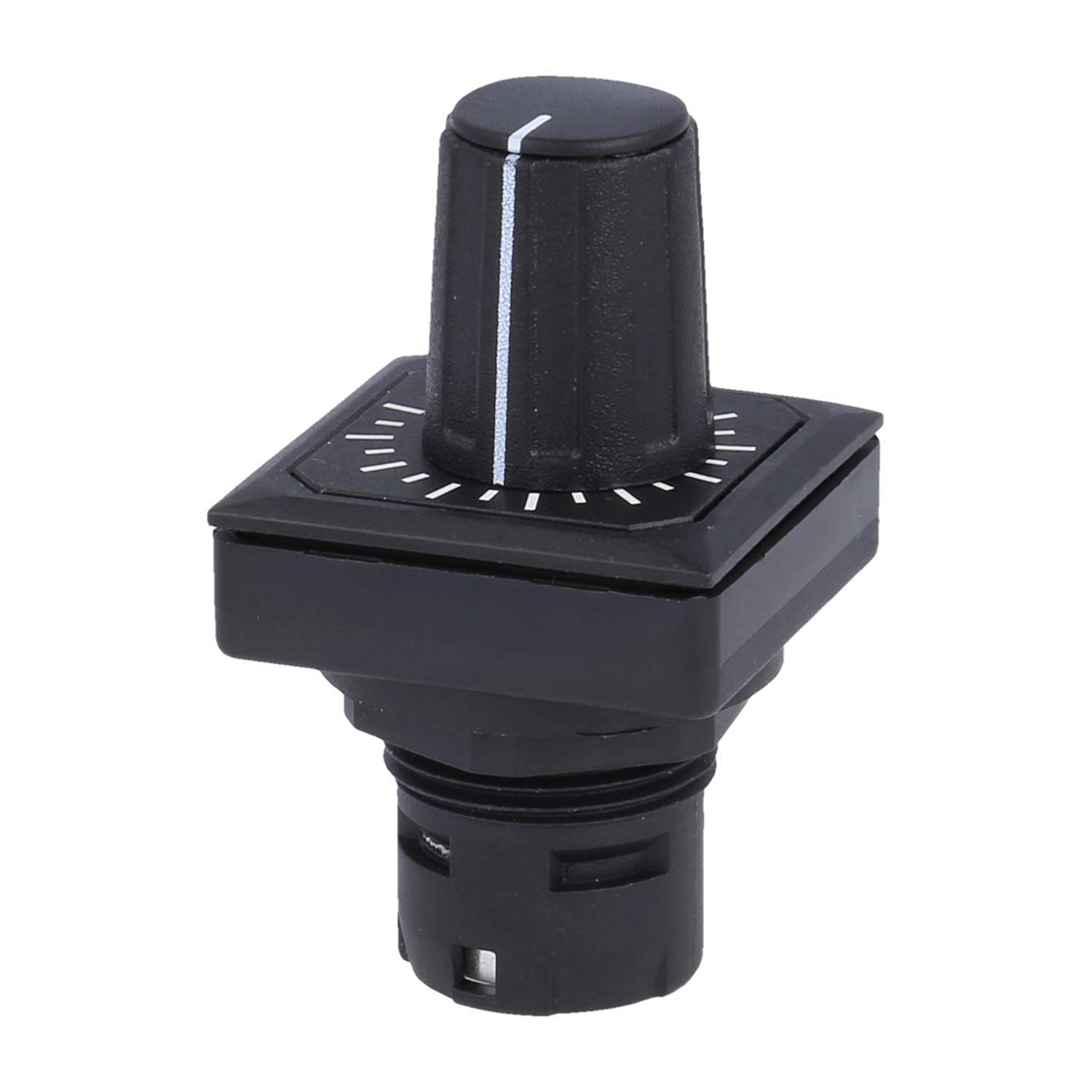 Schwarze Wählscheibe auf einem quadratischen schwarzen Sockel, mit weißen Linien, die verschiedene Positionen markieren. Wird zum Einstellen oder Bedienen von Einstellungen verwendet.