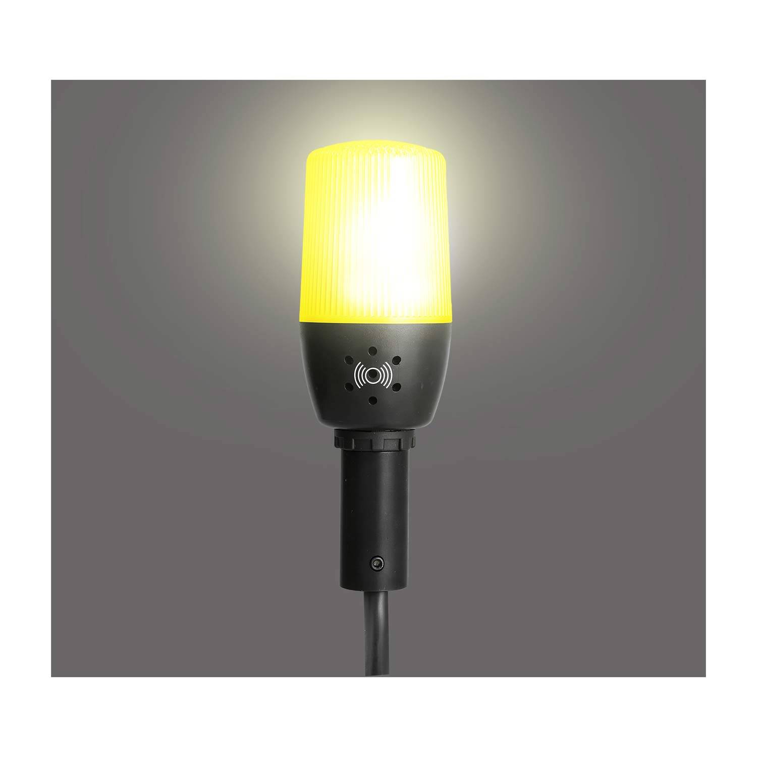 Ein helles gelbes Warnlicht an einem schwarzen Pfahl, das Aufmerksamkeit oder Vorsicht signalisiert, vor einem grauen Hintergrund.