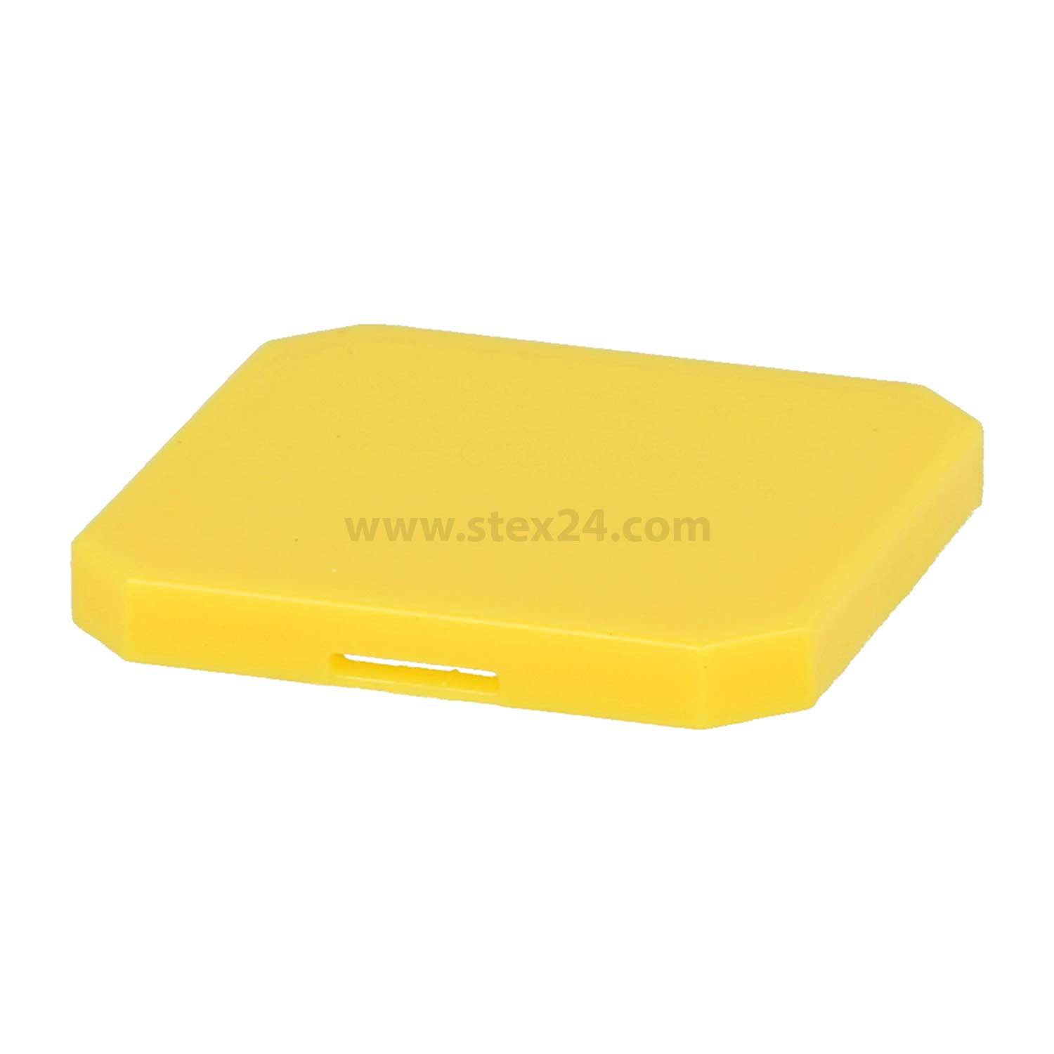Ein gelbes, flaches, sechseckiges Objekt mit glatten Kanten, höchstwahrscheinlich ein Verpackungsdeckel, der vor einem schlichten weißen Hintergrund präsentiert wird.