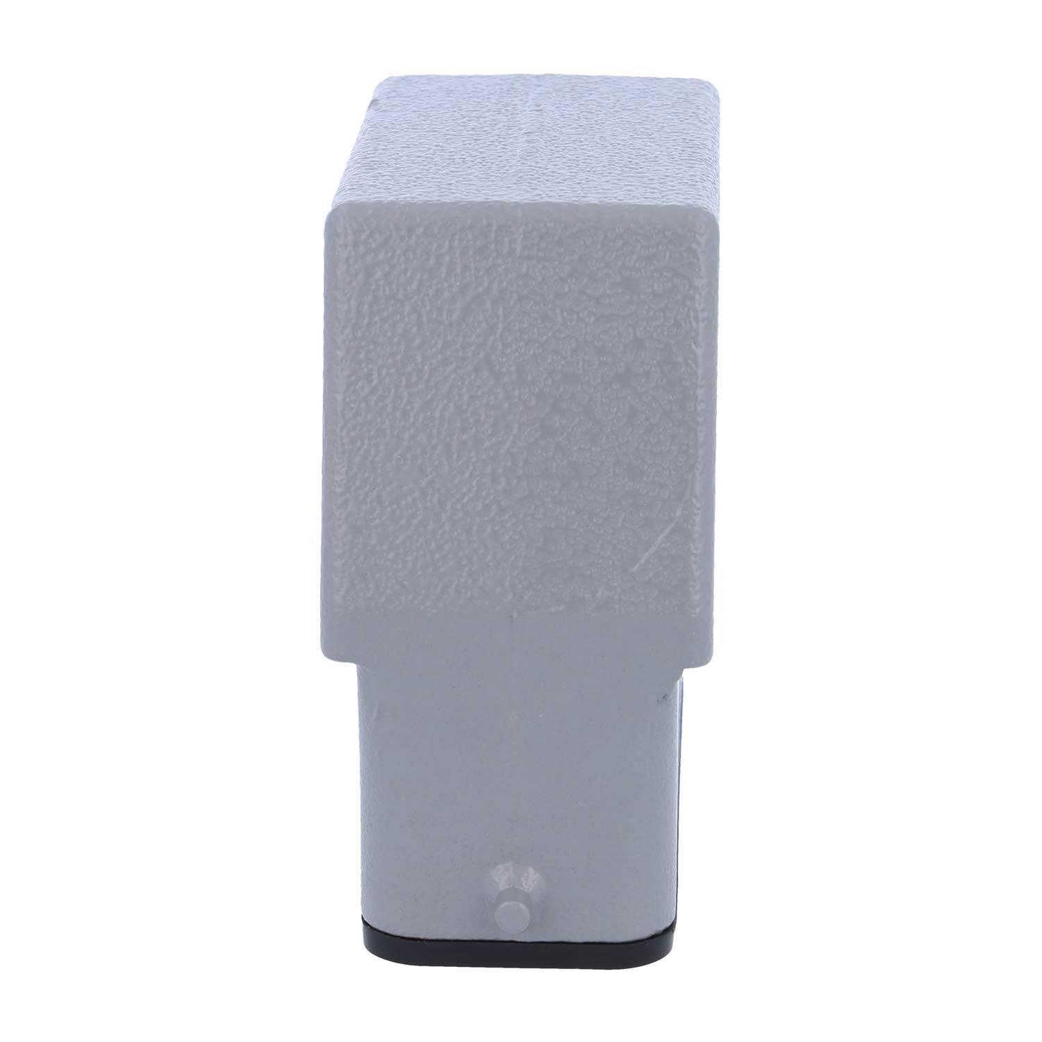 Ein rechteckiger, strukturierter grauer Gegenstand mit einer schmalen Basis und einem breiteren Oberteil, der einem stilisierten Kopf oder einer abstrakten Skulptur ähnelt, vor einem einfarbigen Hintergrund.