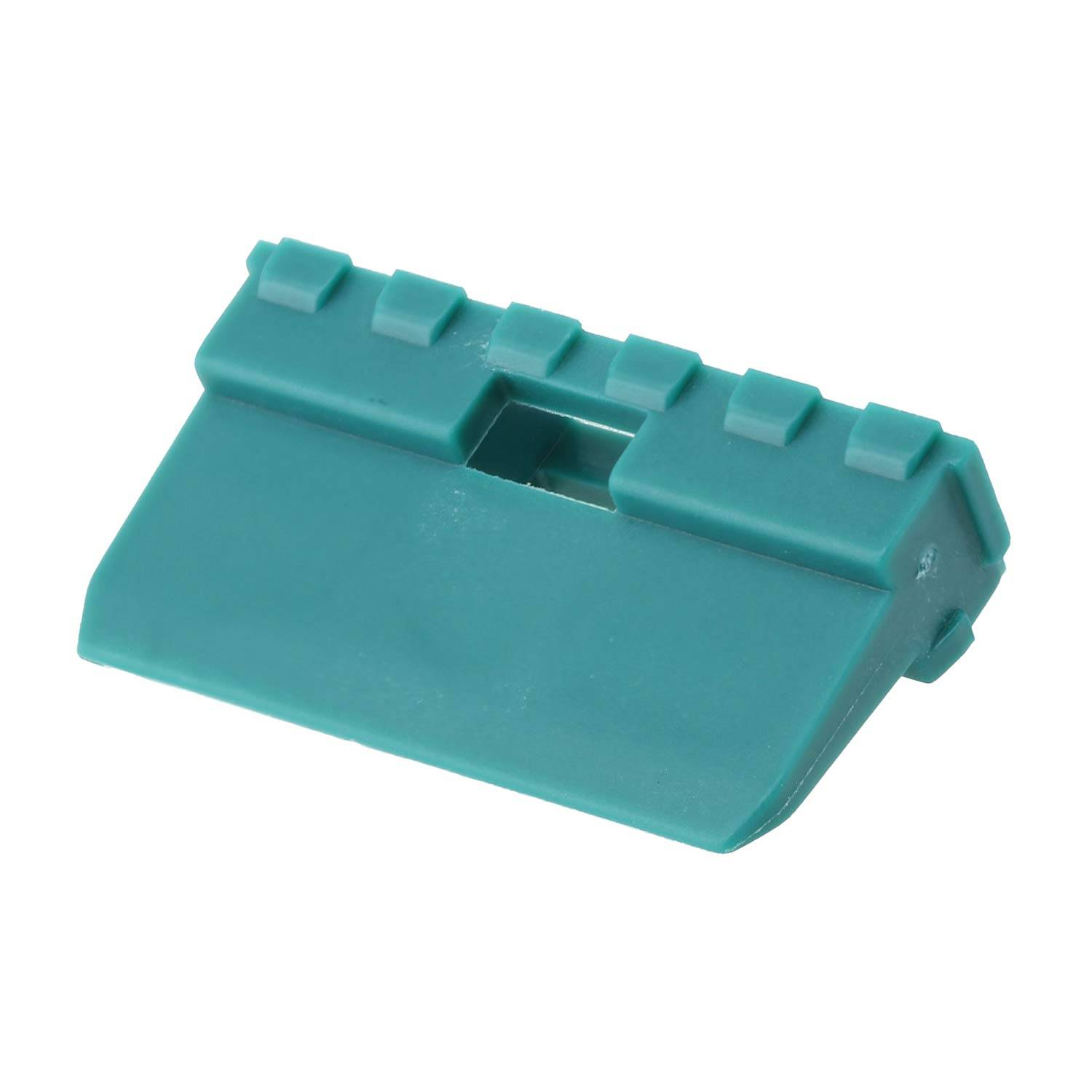 Ein türkisfarbenes Plastikrechteckobjekt mit Rillen auf der Oberseite, möglicherweise eine Klammer oder eine kleine Schachtel, vor einem weißen Hintergrund abgebildet.
