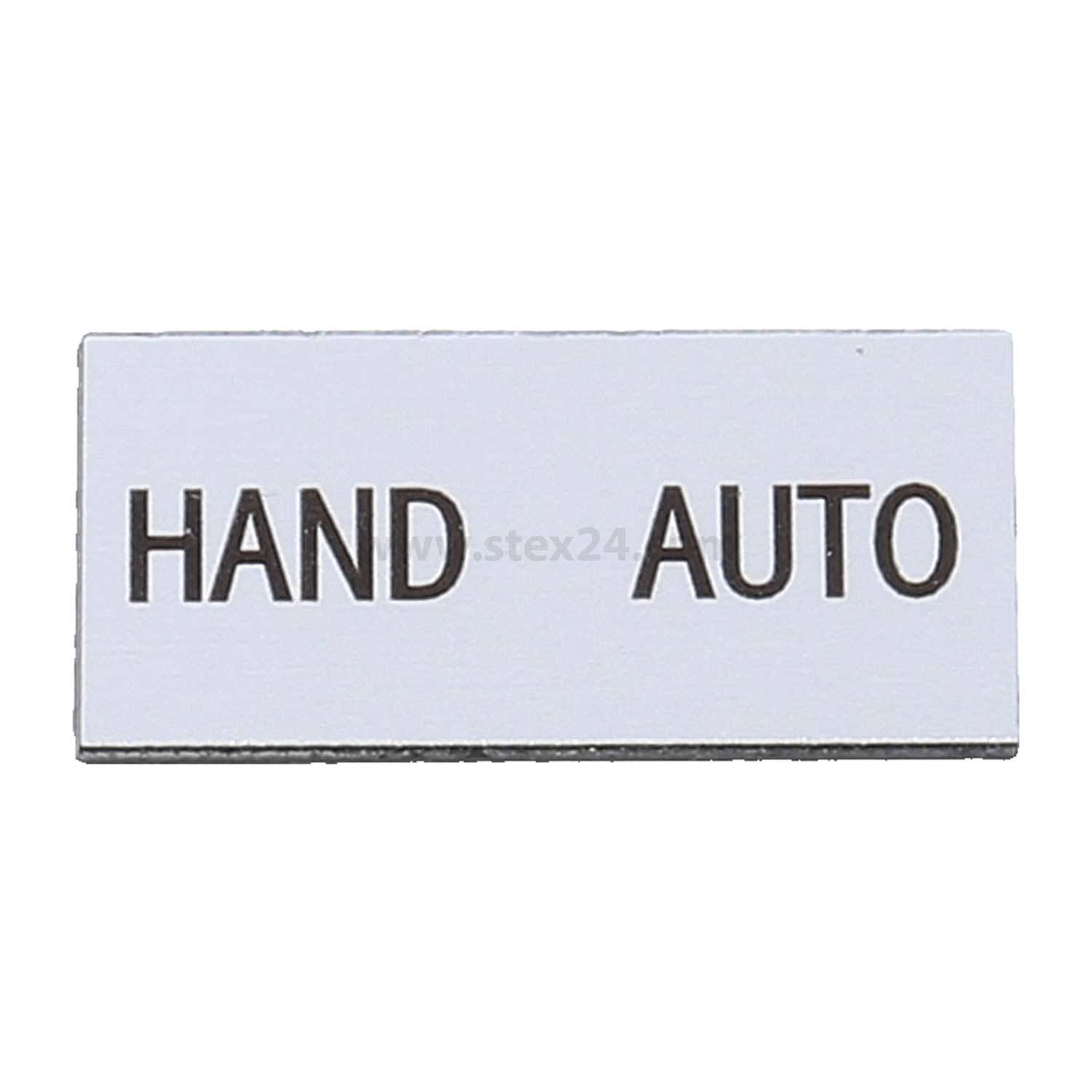 Ein rechteckiges Schild zeigt links das Wort 'HAND' und rechts 'AUTO', was manuelle und automatische Optionen anzeigt.