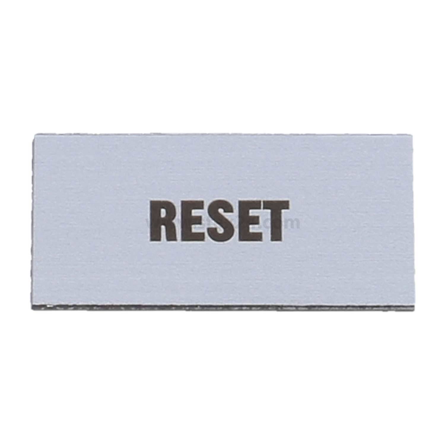 Ein rechteckiger Knopf mit der Beschriftung „RESET