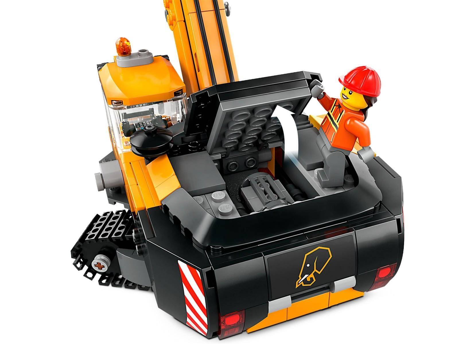 LEGO-Bauarbeiterfigur, die in der Ladefläche eines schwarz-orangen Kranwagens steht und den Kranarm vor weißem Hintergrund hält.