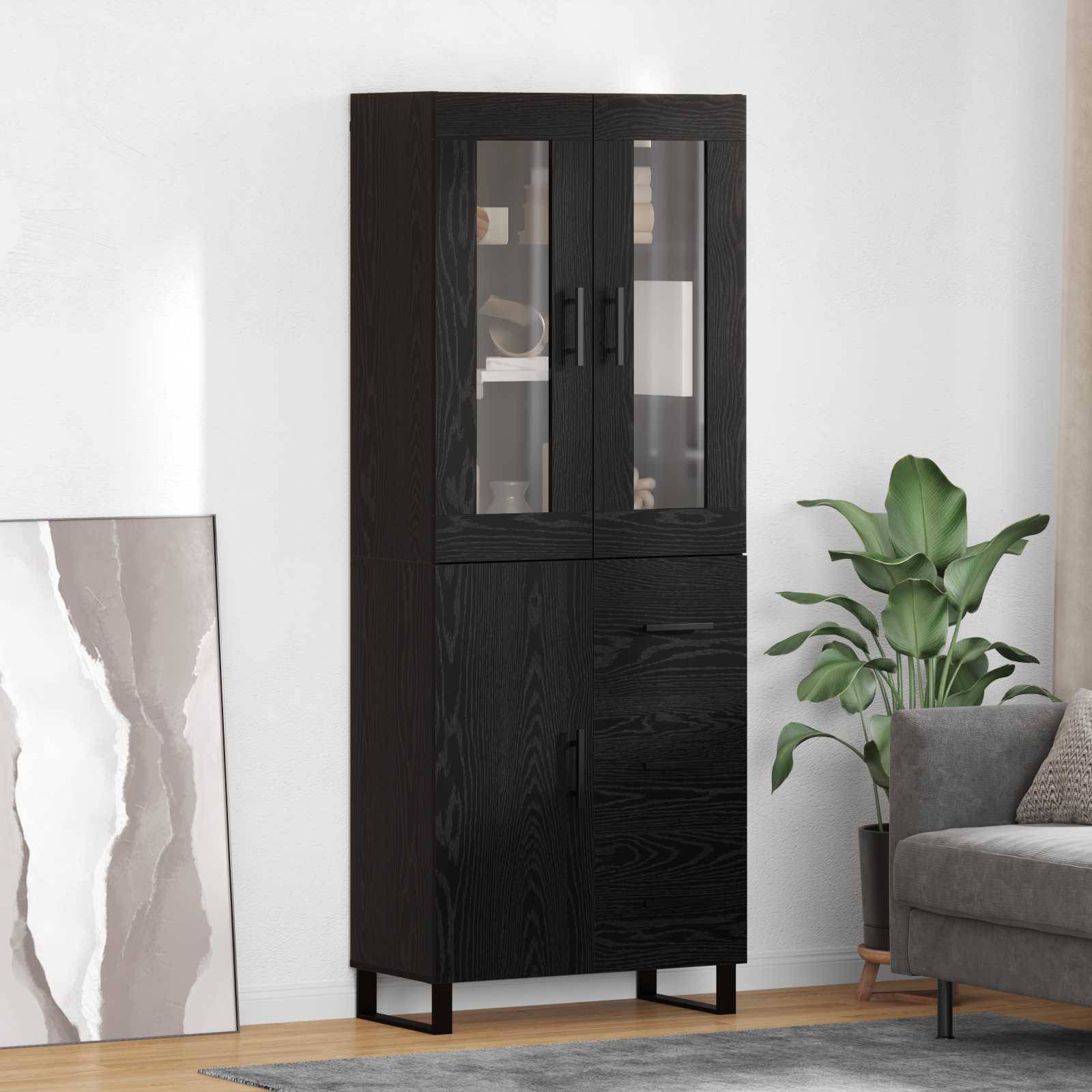 Ein hoher, schwarzer Holzschrank mit Glastüren zeigt ausgestellte Gegenstände, und steht neben einem grauen Sofa und einer hohen grünen Pflanze in einem modernen Wohnzimmer.