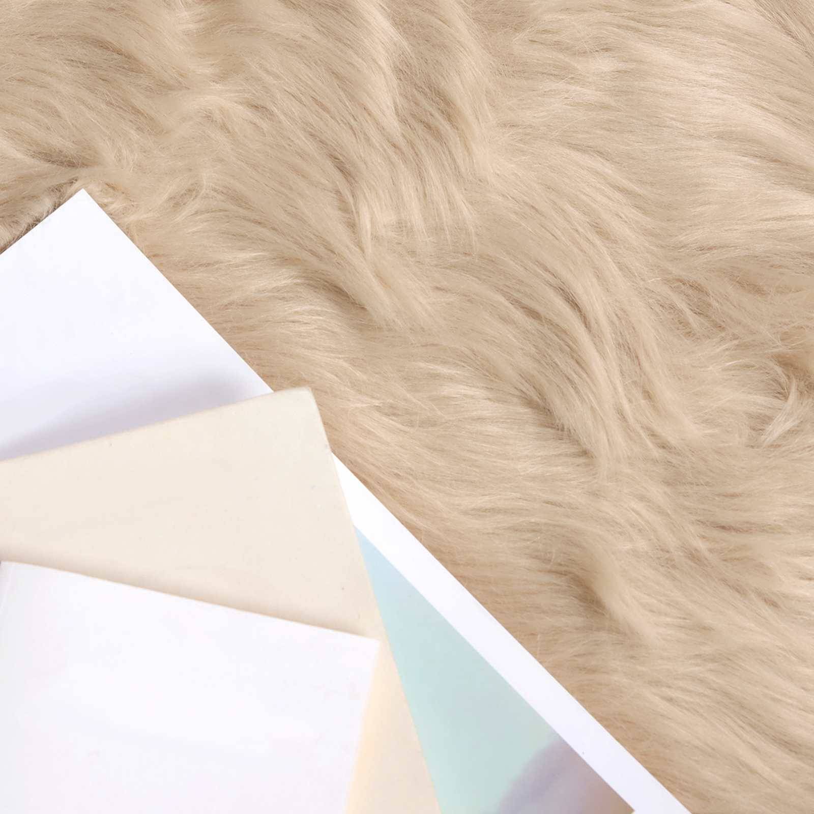Beige und weiße Bücher überlappen sich auf einer flauschigen, hellbraunen Oberfläche und betonen Textur und neutrale Töne.