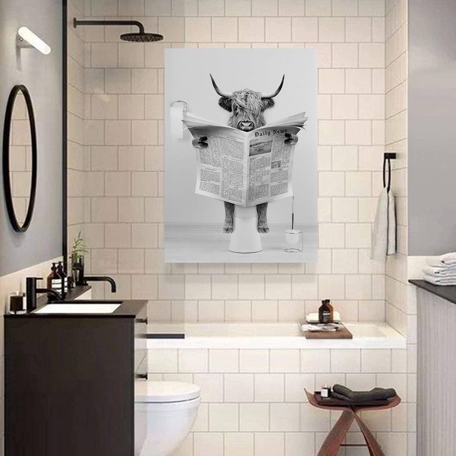 Ein Schwarz-Weiß-Foto eines modernen Badezimmers zeigt ein humorvolles gerahmtes Bild einer Kuh, die eine Zeitung liest, an der Wand.