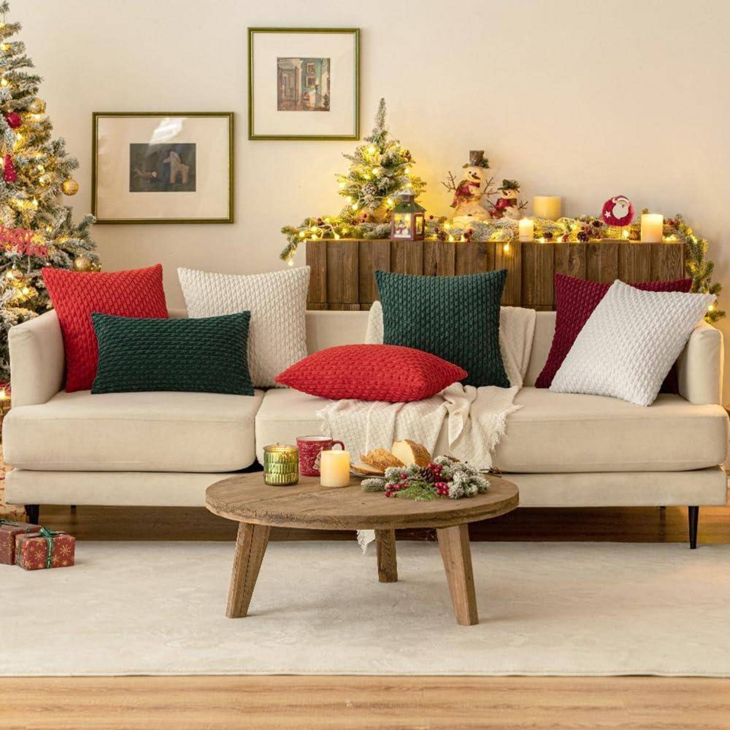 Ein gemütliches Wohnzimmer, festlich für die Feiertage dekoriert, mit einem Sofa, das mit roten, weißen und grünen Kissen geschmückt ist, und einem festlichen Baum mit Lichtern.